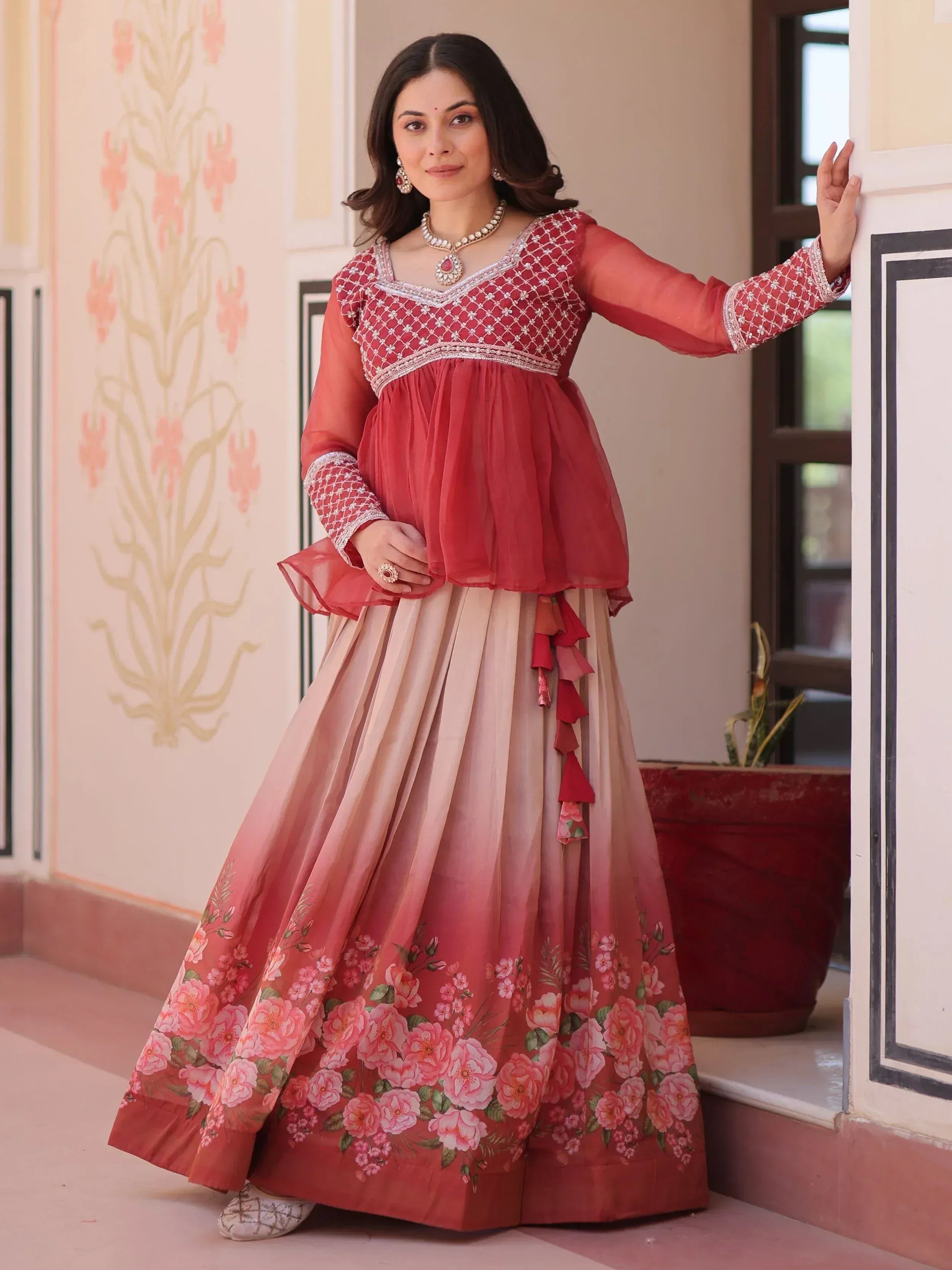 Woman in red embroidered top with floral print lehenga, Indian ethnic wear for festive occasions