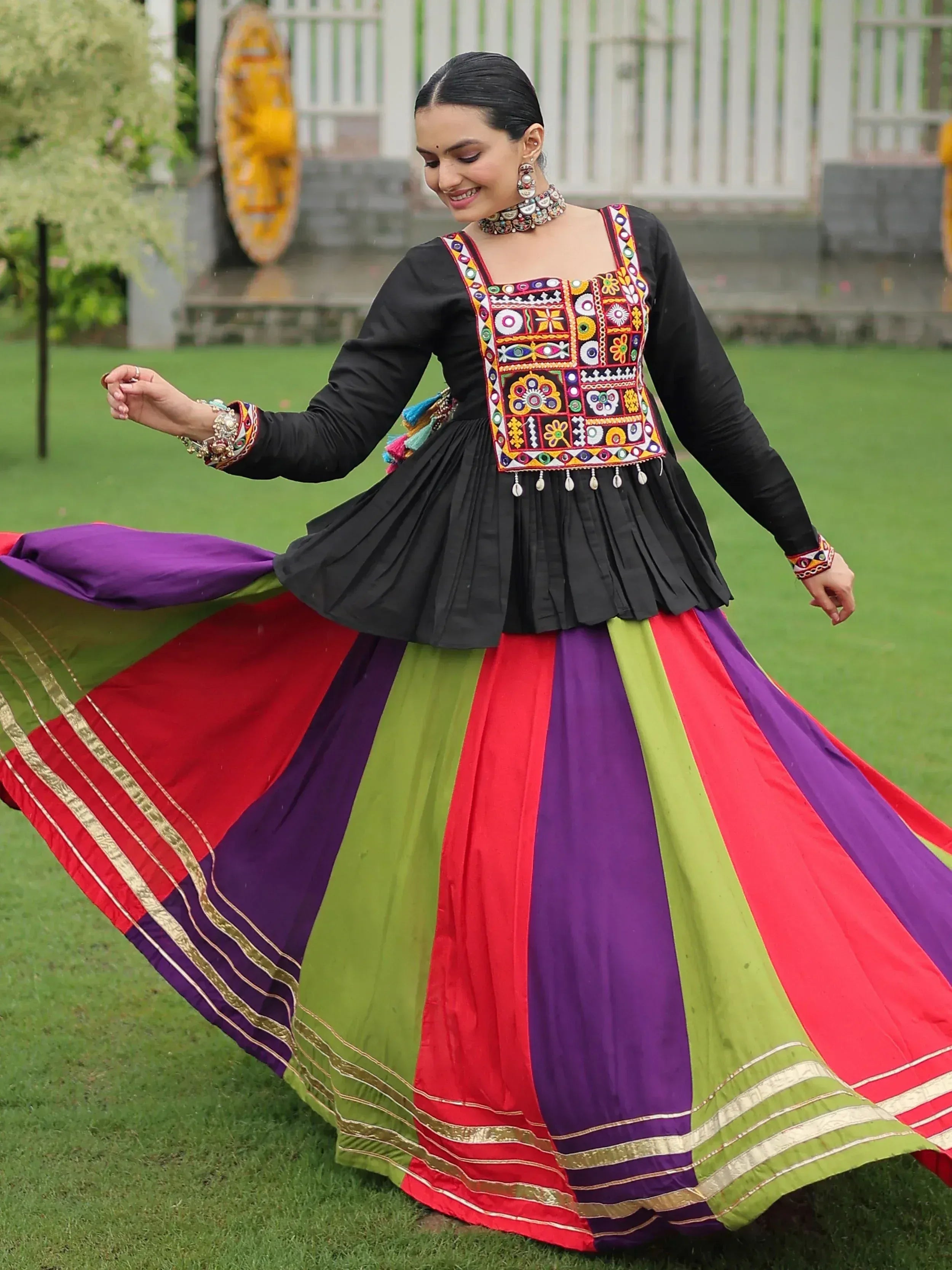 Colorful ethnic gown with embroidered top and striped skirt, perfect for festive occasions.
