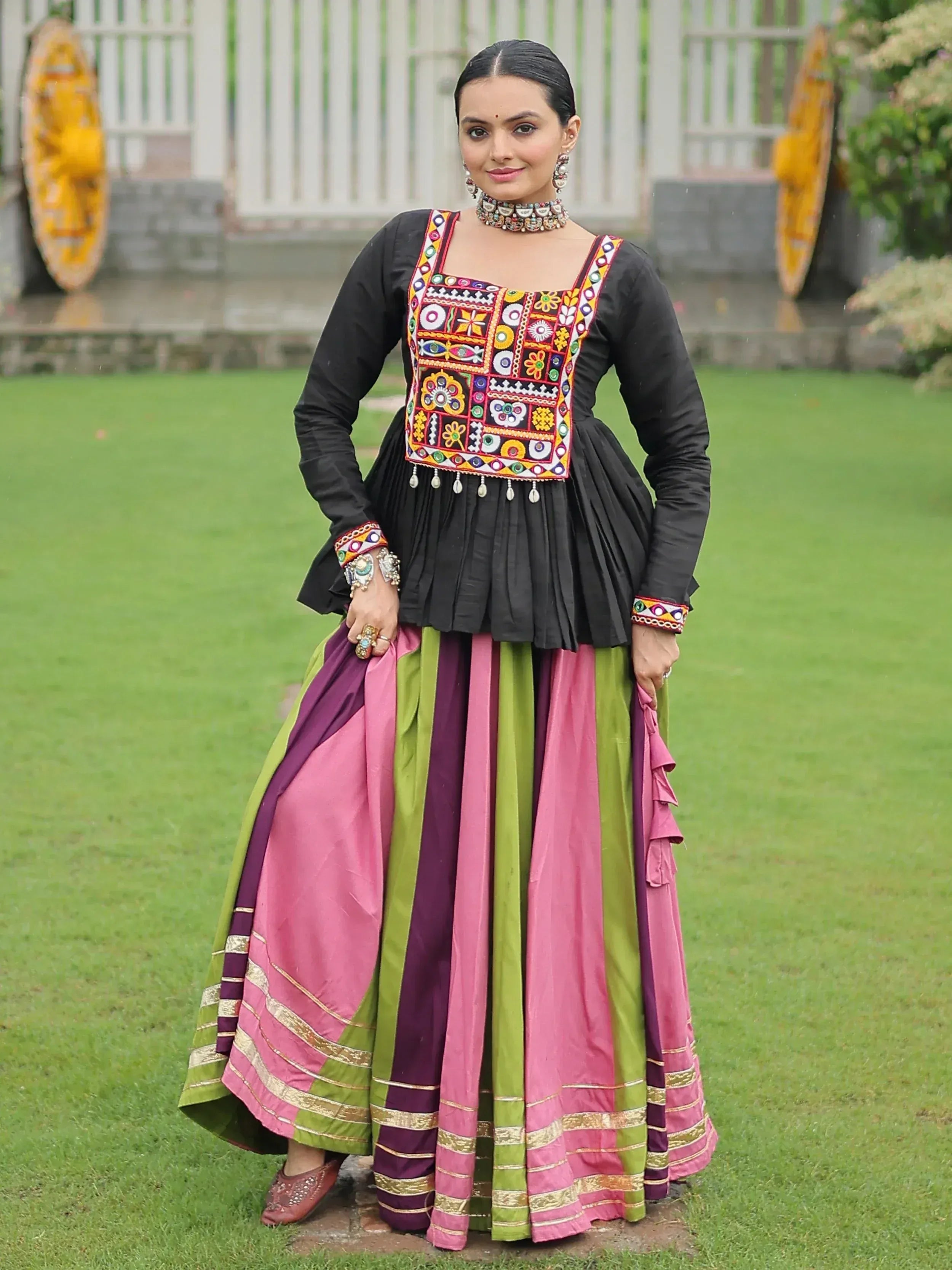 Woman in colorful embroidered Indian ethnic wear with black top and striped skirt