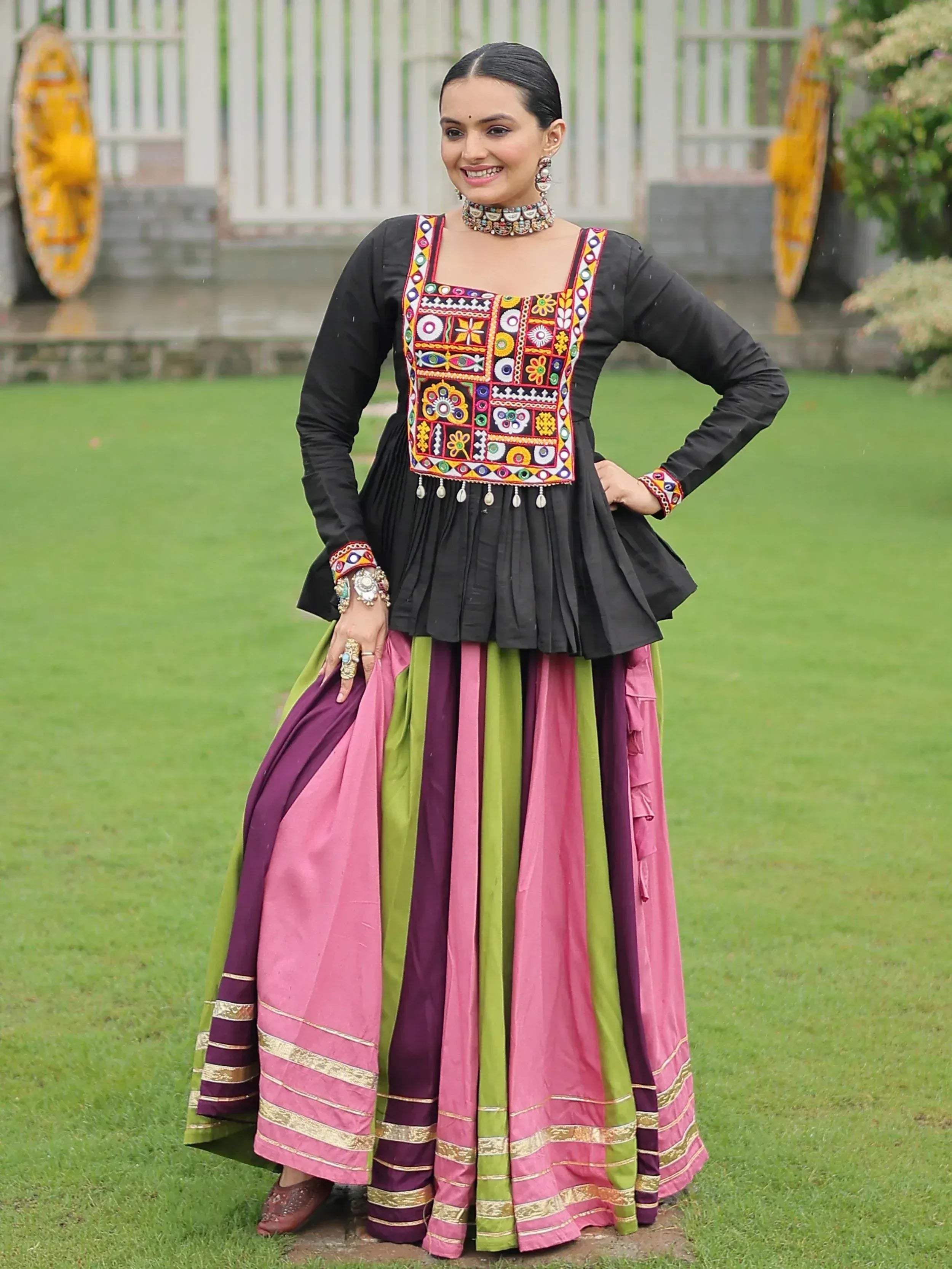 Black embroidered top with colorful pink and green lehenga, traditional Indian ethnic wear