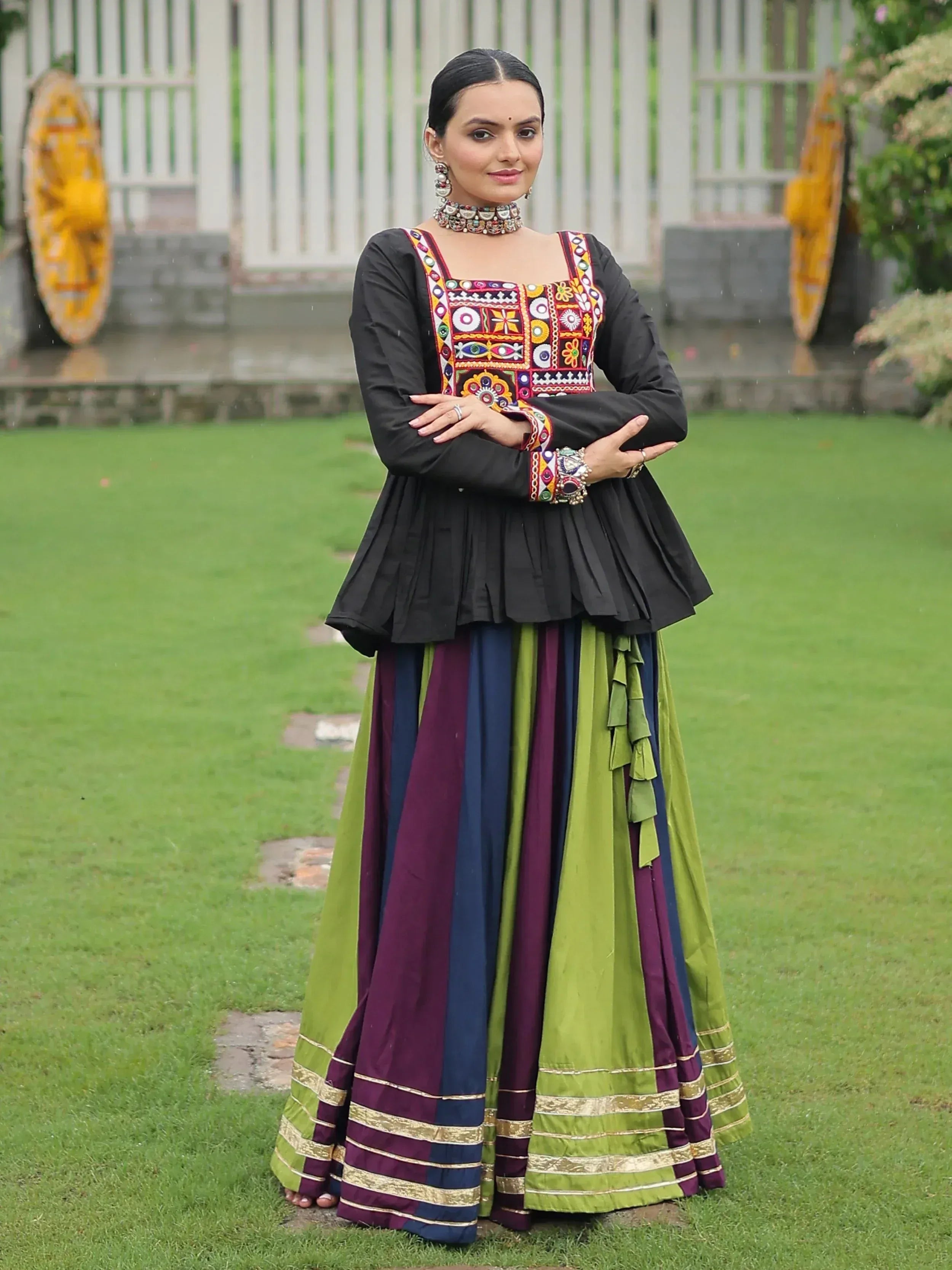 Woman in black embroidered top with colorful striped skirt, traditional Indian ethnic wear