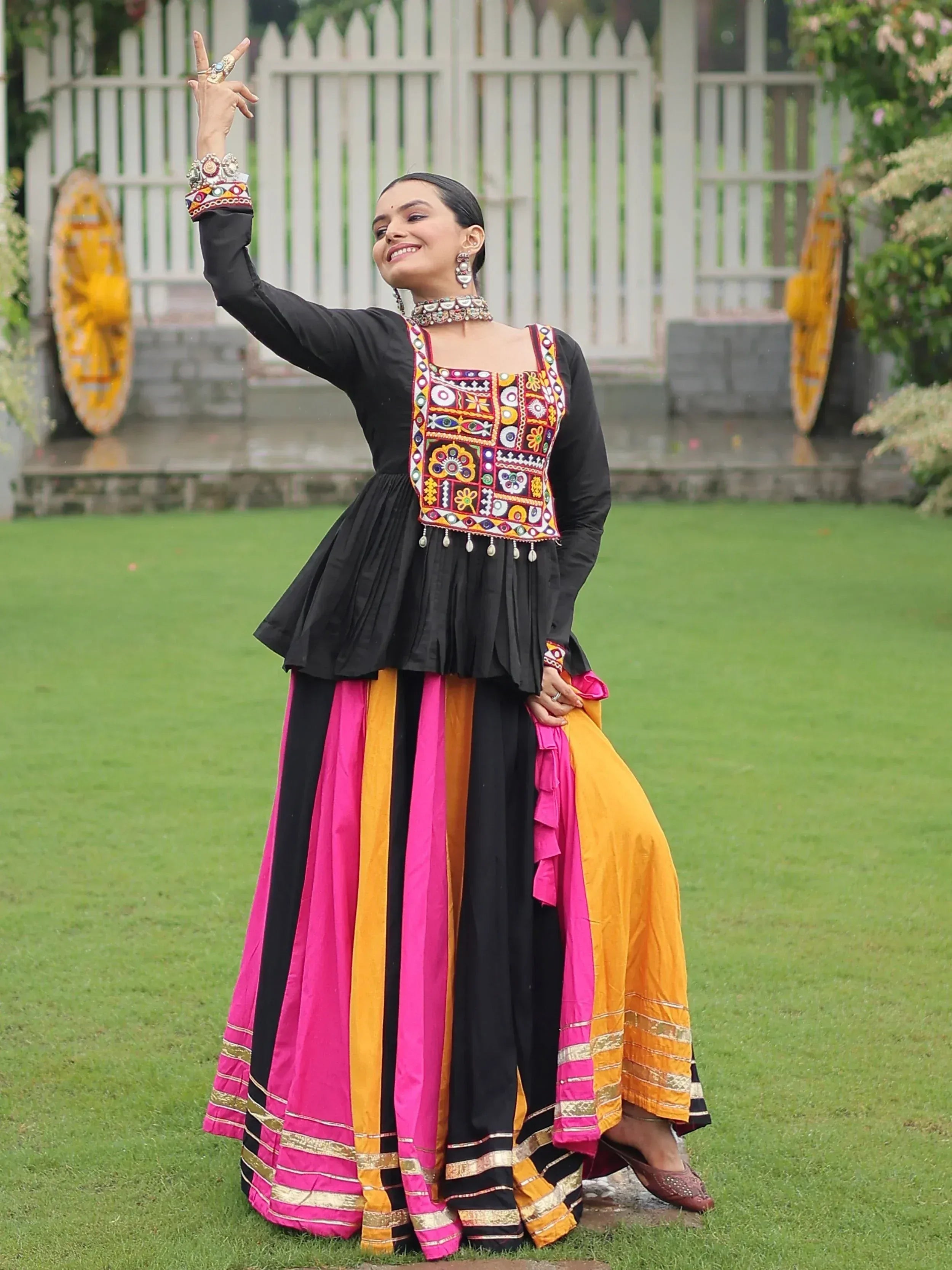 Woman in black embroidered top with colorful striped skirt, traditional Indian ethnic wear