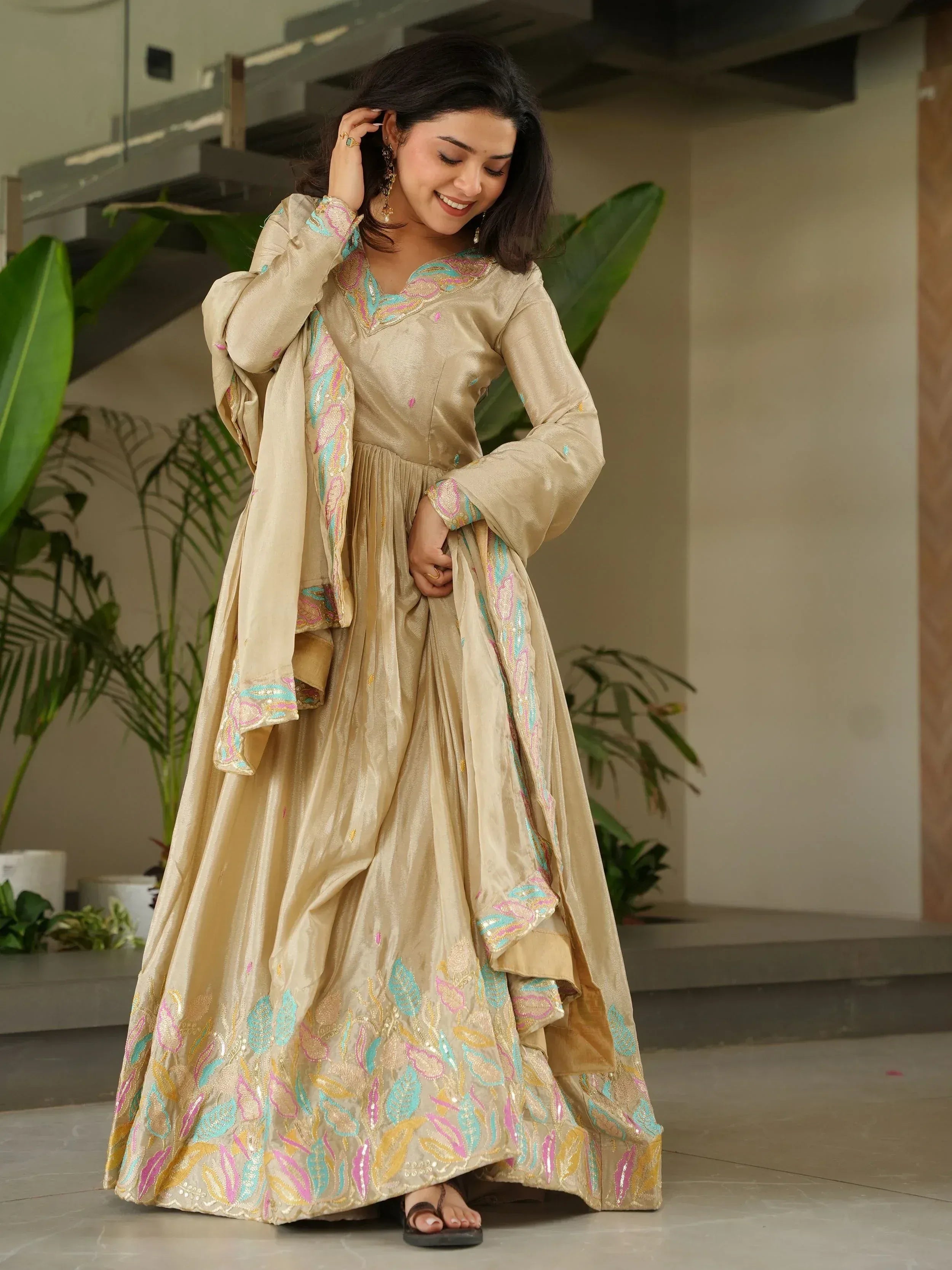 Beige embroidered ethnic gown with colorful floral patterns, perfect for Indian festive occasions