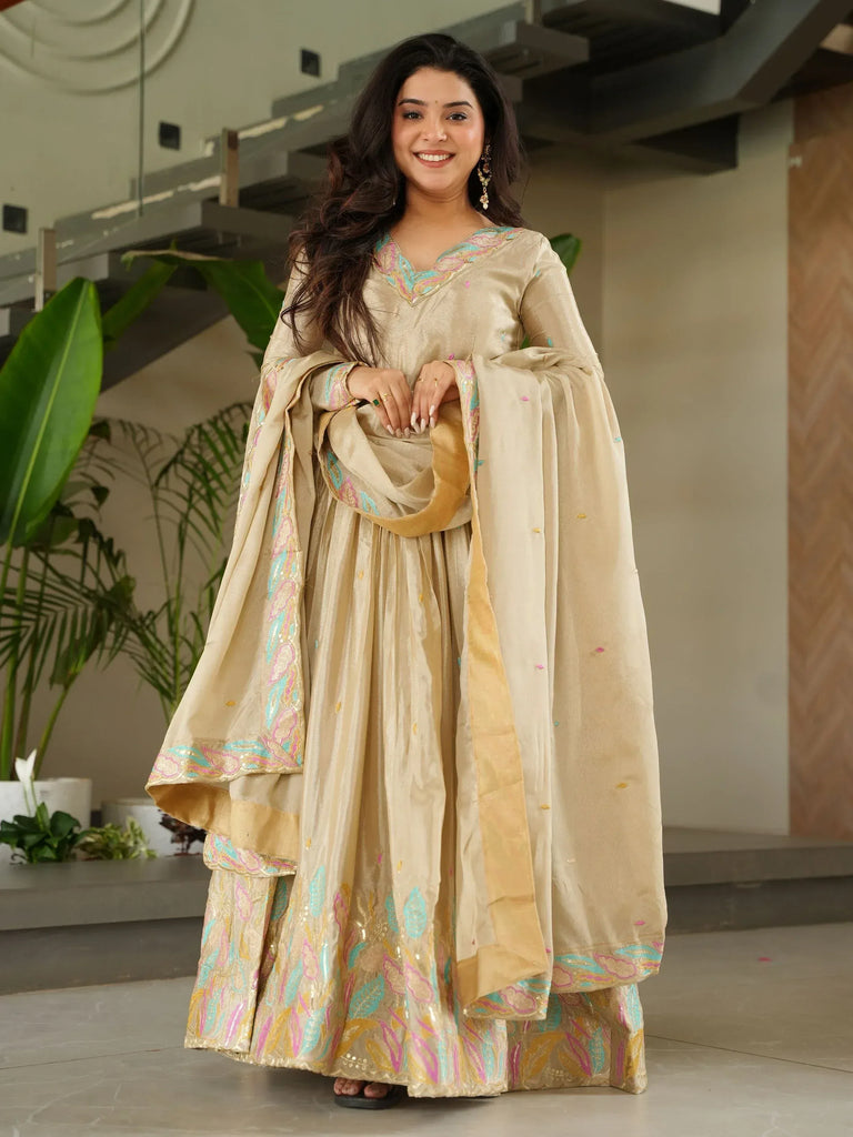 Beige embroidered ethnic gown with colorful floral detailing, perfect for Indian occasions