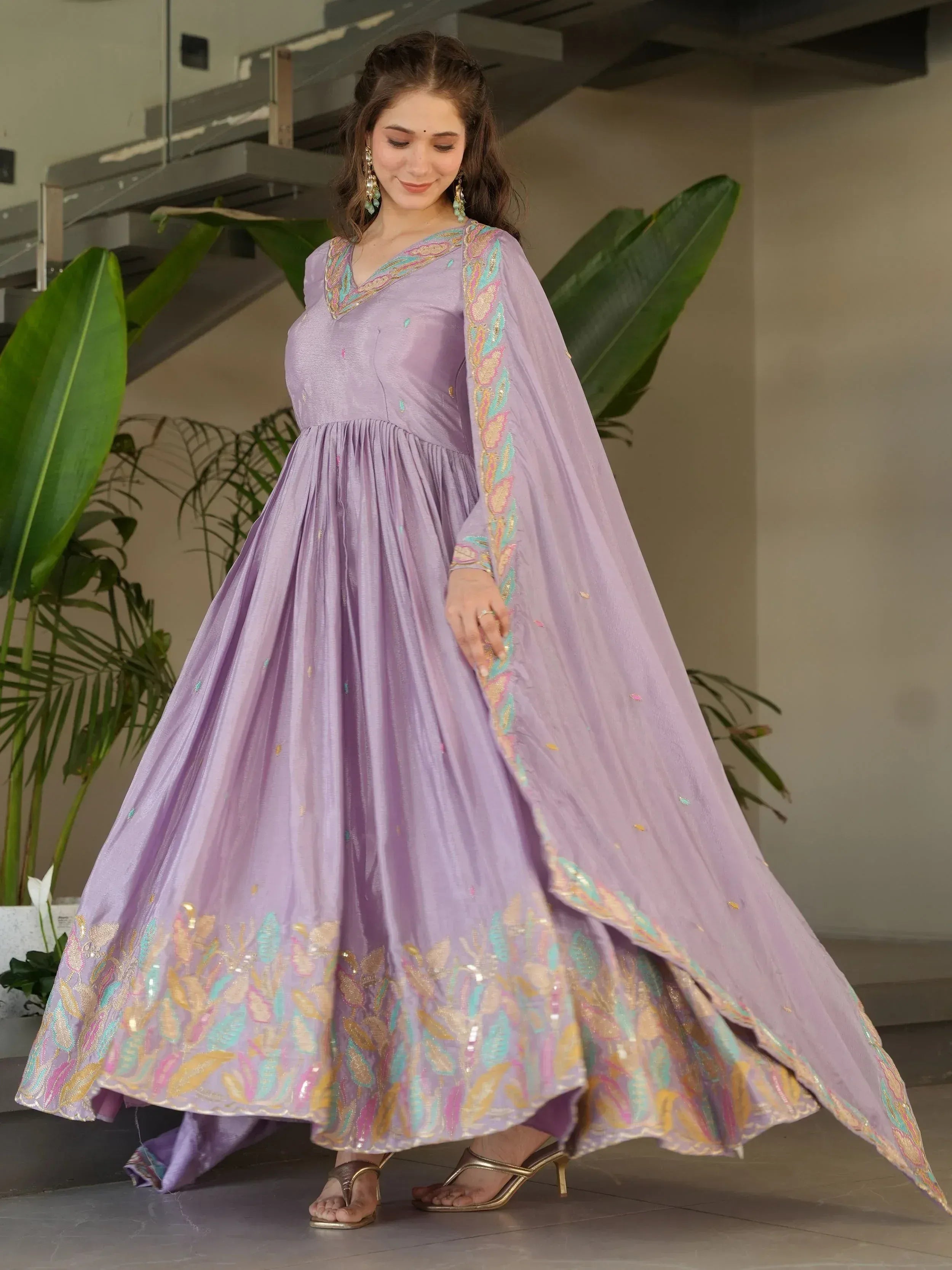 Lavender ethnic gown with colorful embroidery, perfect for Indian weddings and festive occasions.
