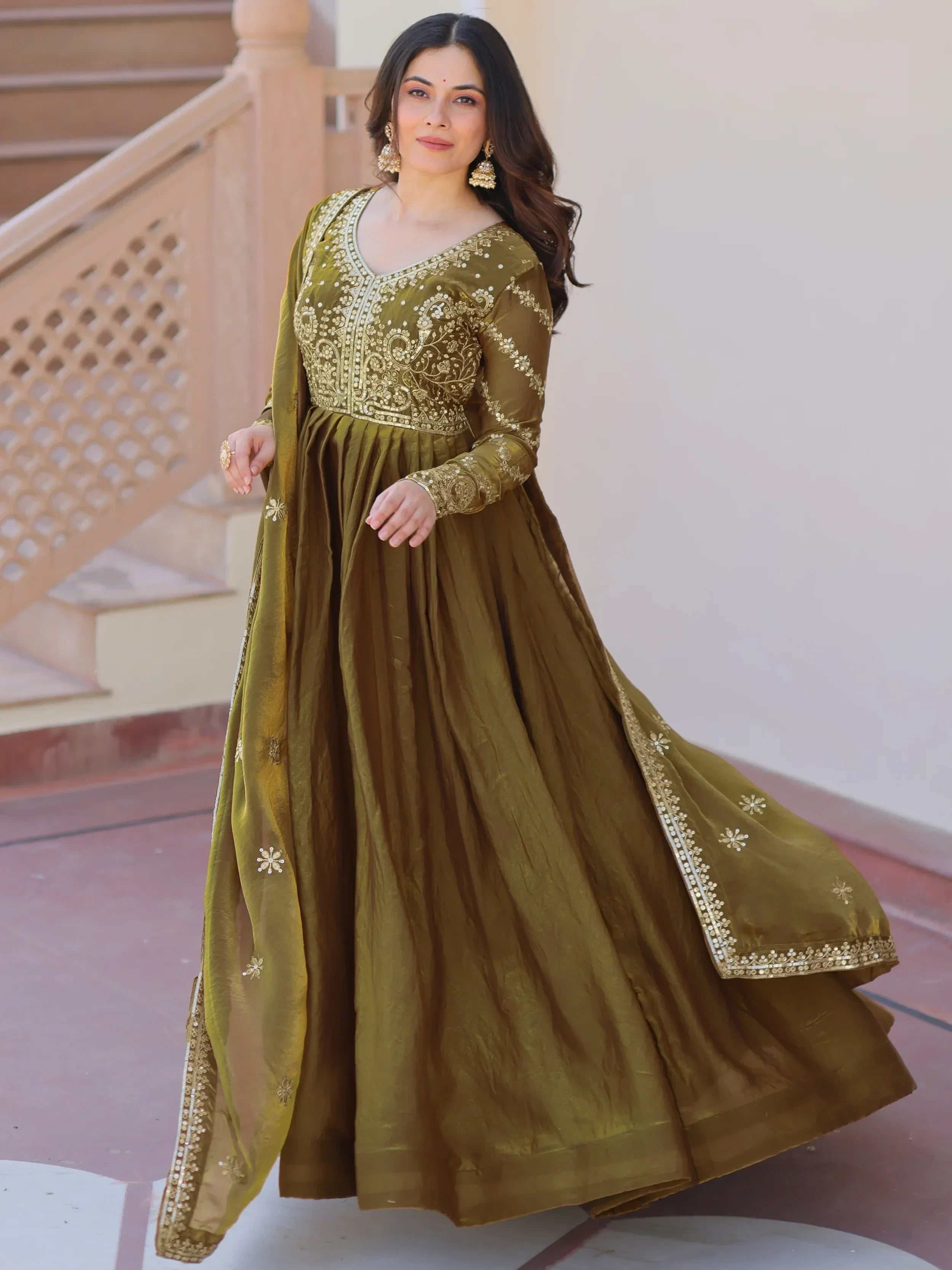 Woman wearing olive green embroidered Anarkali gown with gold accents, ethnic Indian fashion