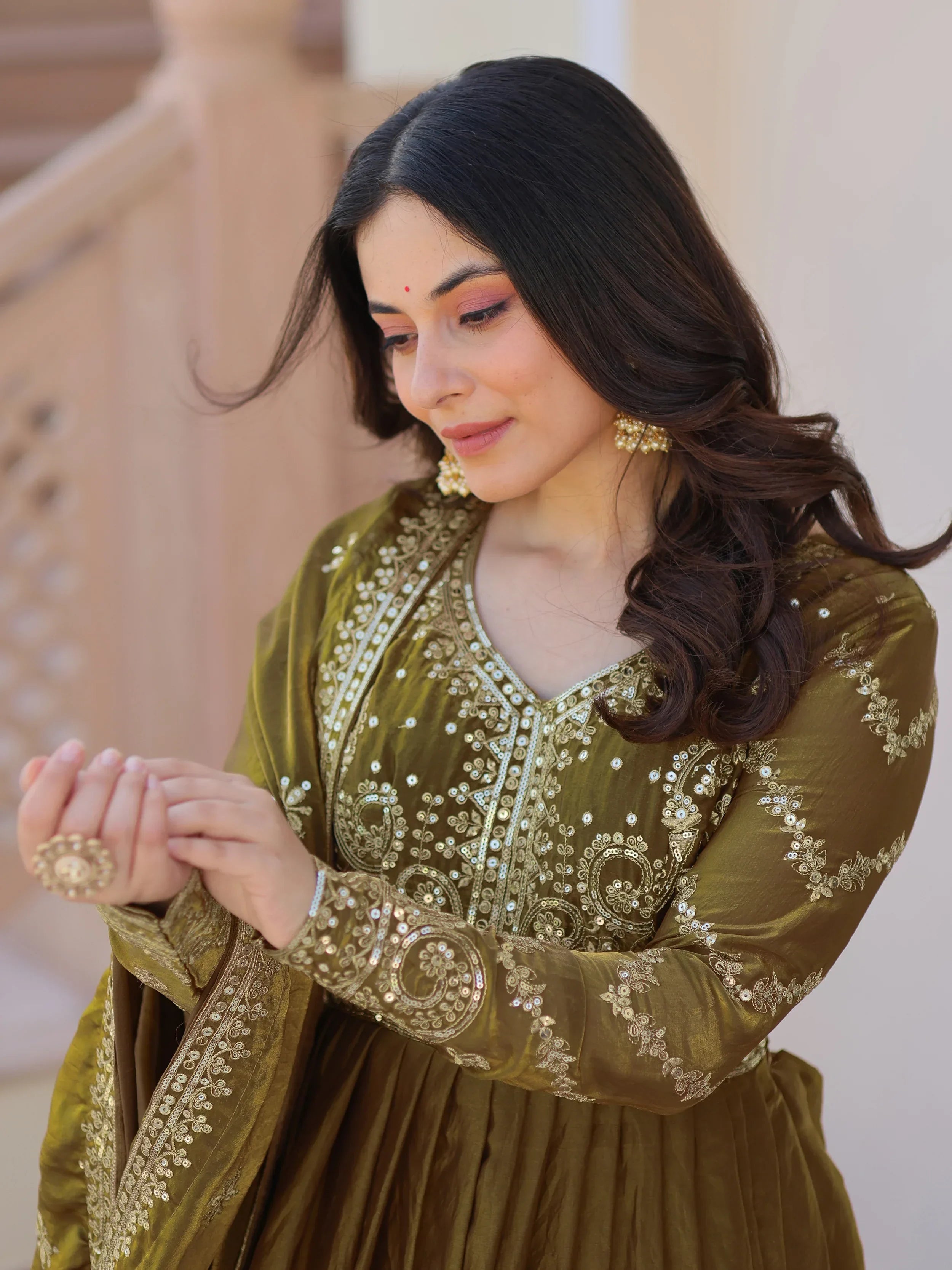 Woman wearing olive green embroidered Anarkali suit with gold jewelry, ethnic fashion