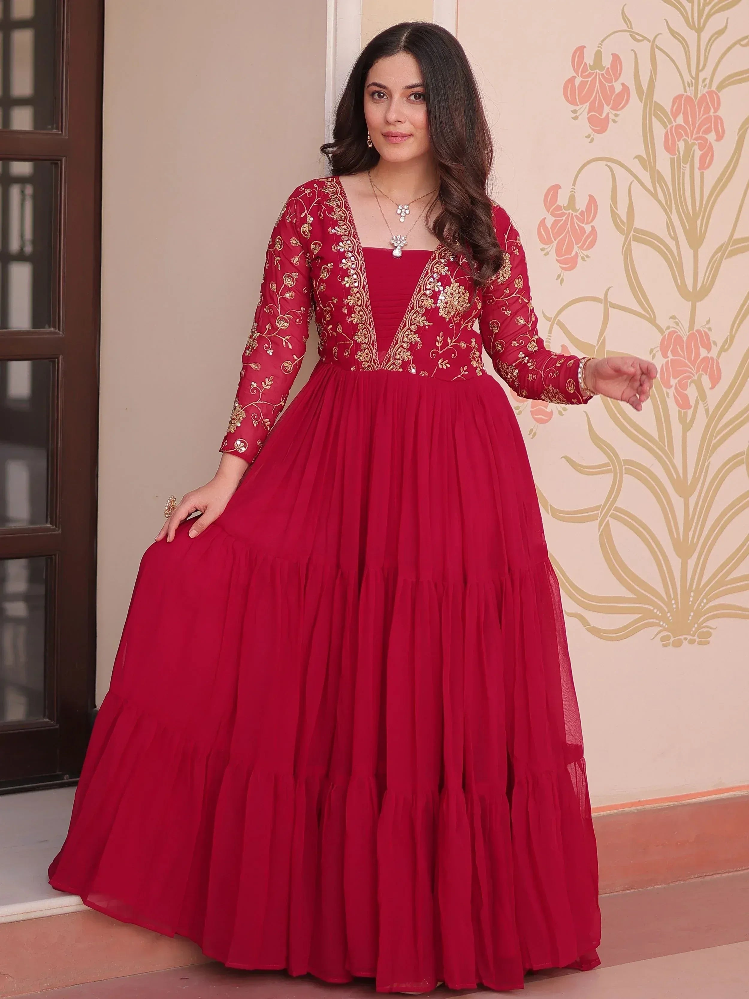 Red embroidered ethnic gown with gold detailing, perfect for Indian weddings and festive occasions.