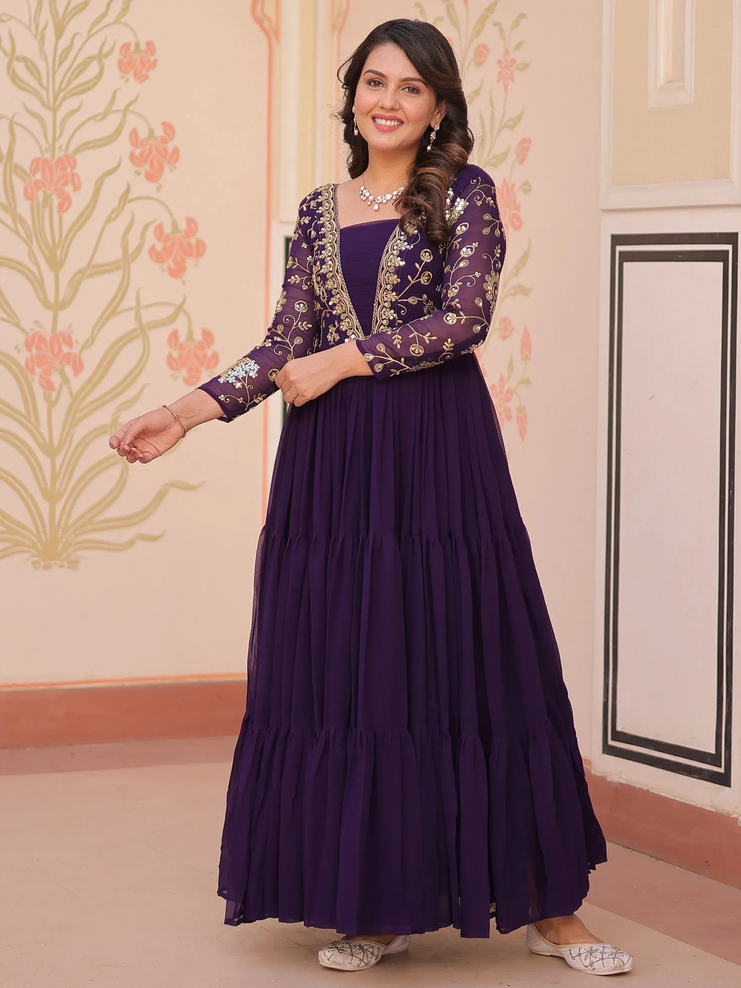 Purple ethnic gown with gold embroidery, pleated skirt, and sheer sleeves for Indian occasions