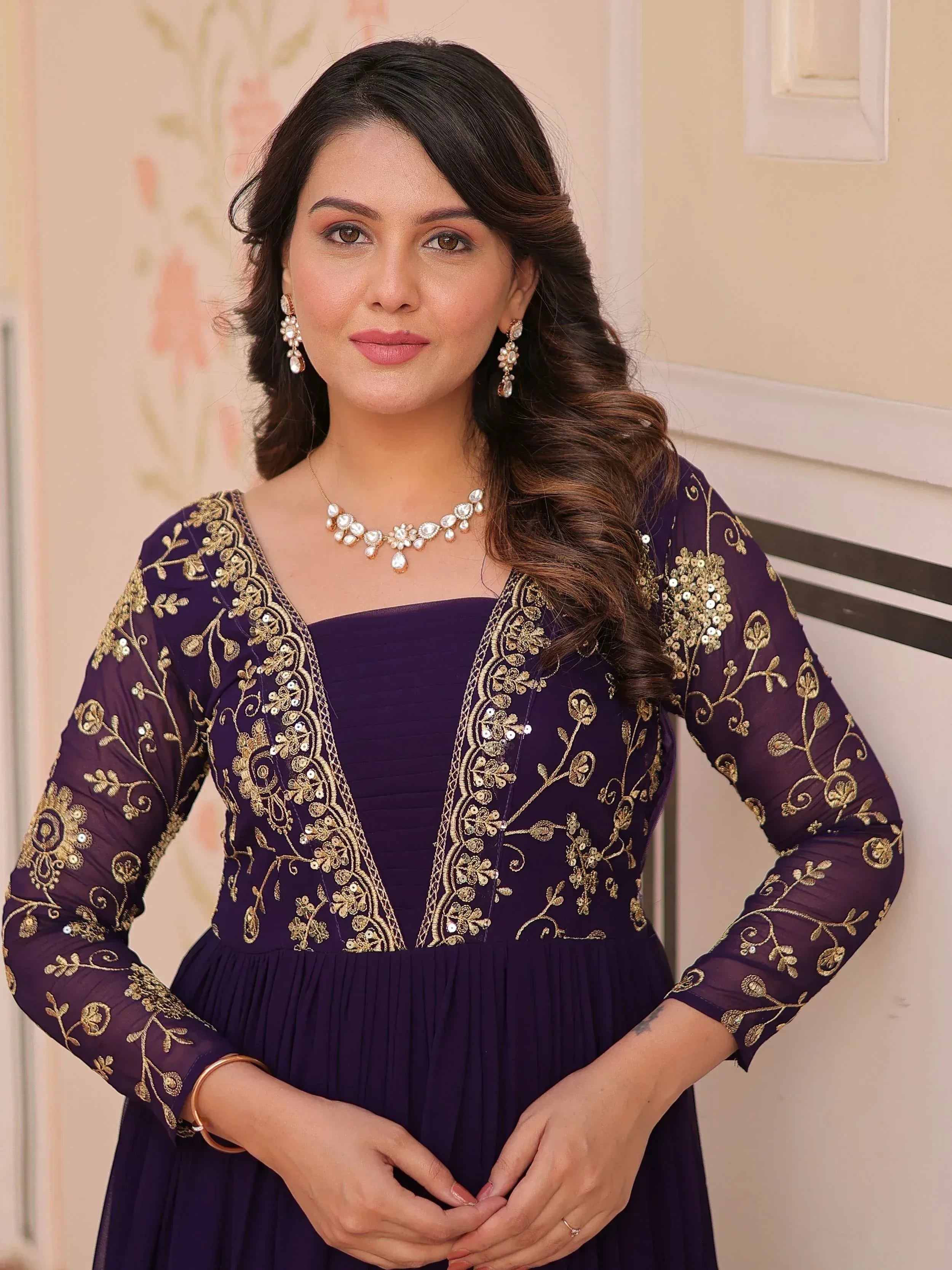 Elegant purple ethnic gown with gold embroidery and matching jewelry for festive occasions