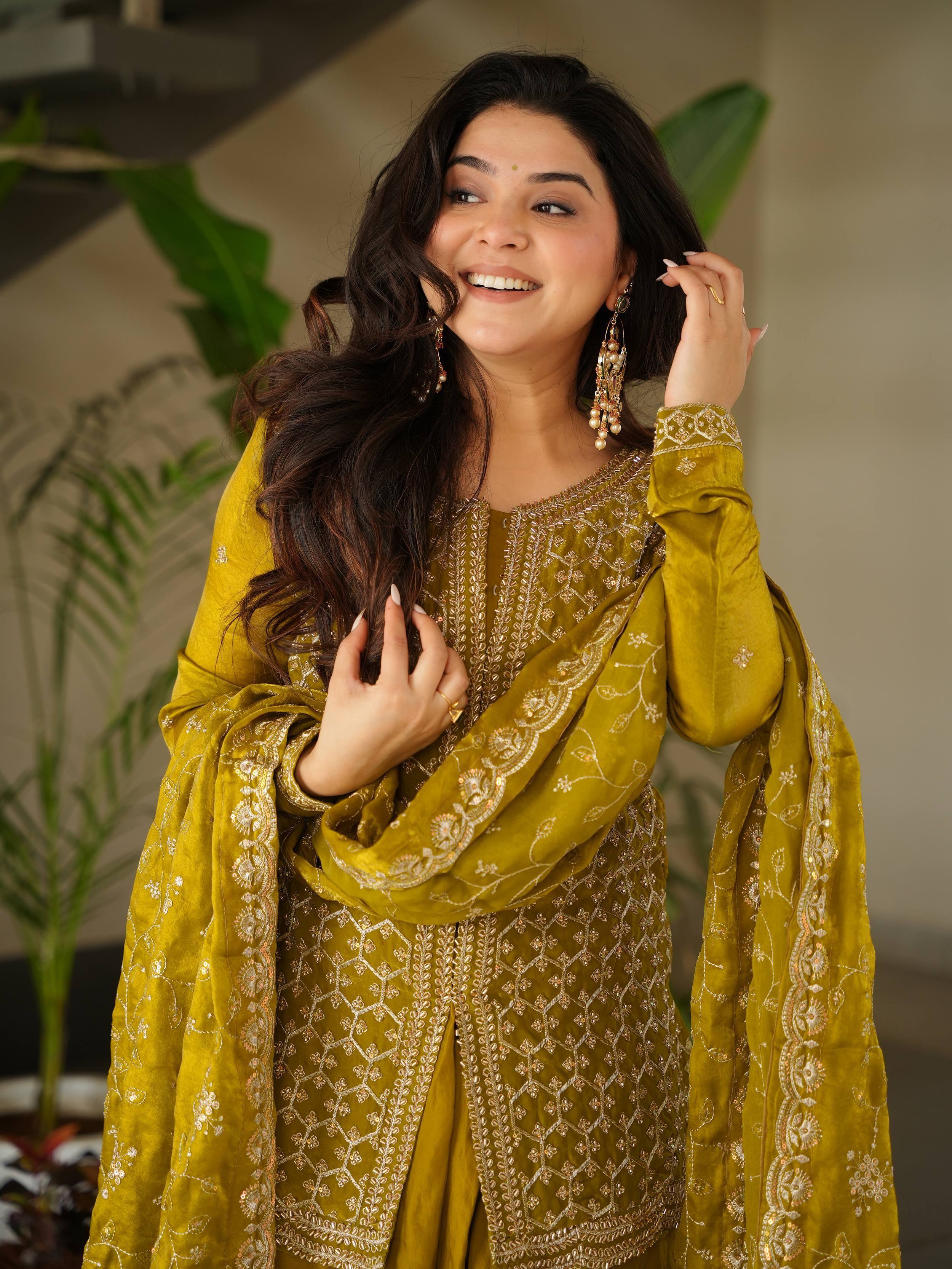 Woman in mustard yellow embroidered salwar kameez with gold detailing, perfect for ethnic occasions