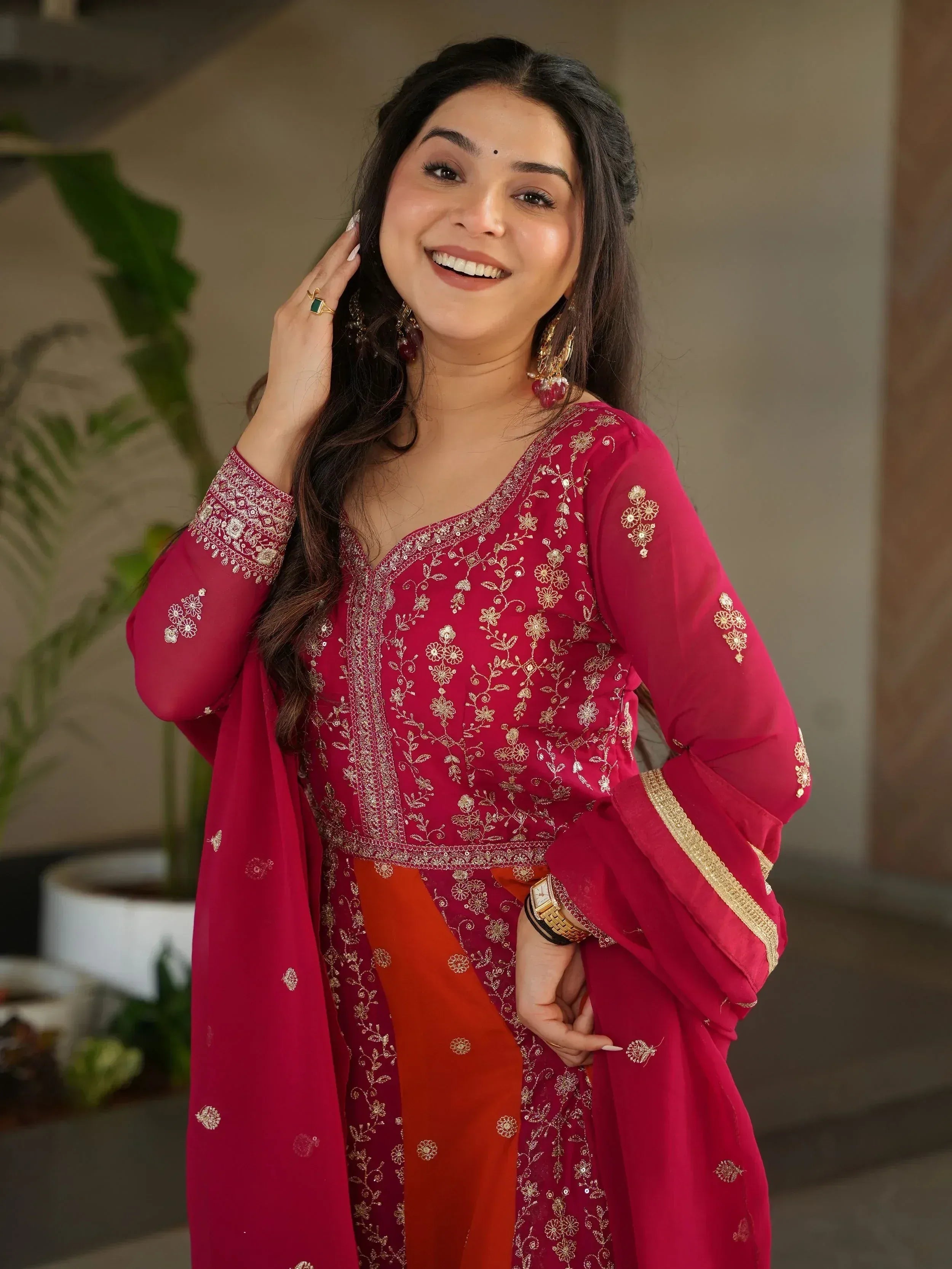 Woman in red embroidered ethnic gown with gold detailing, perfect for Indian festive occasions