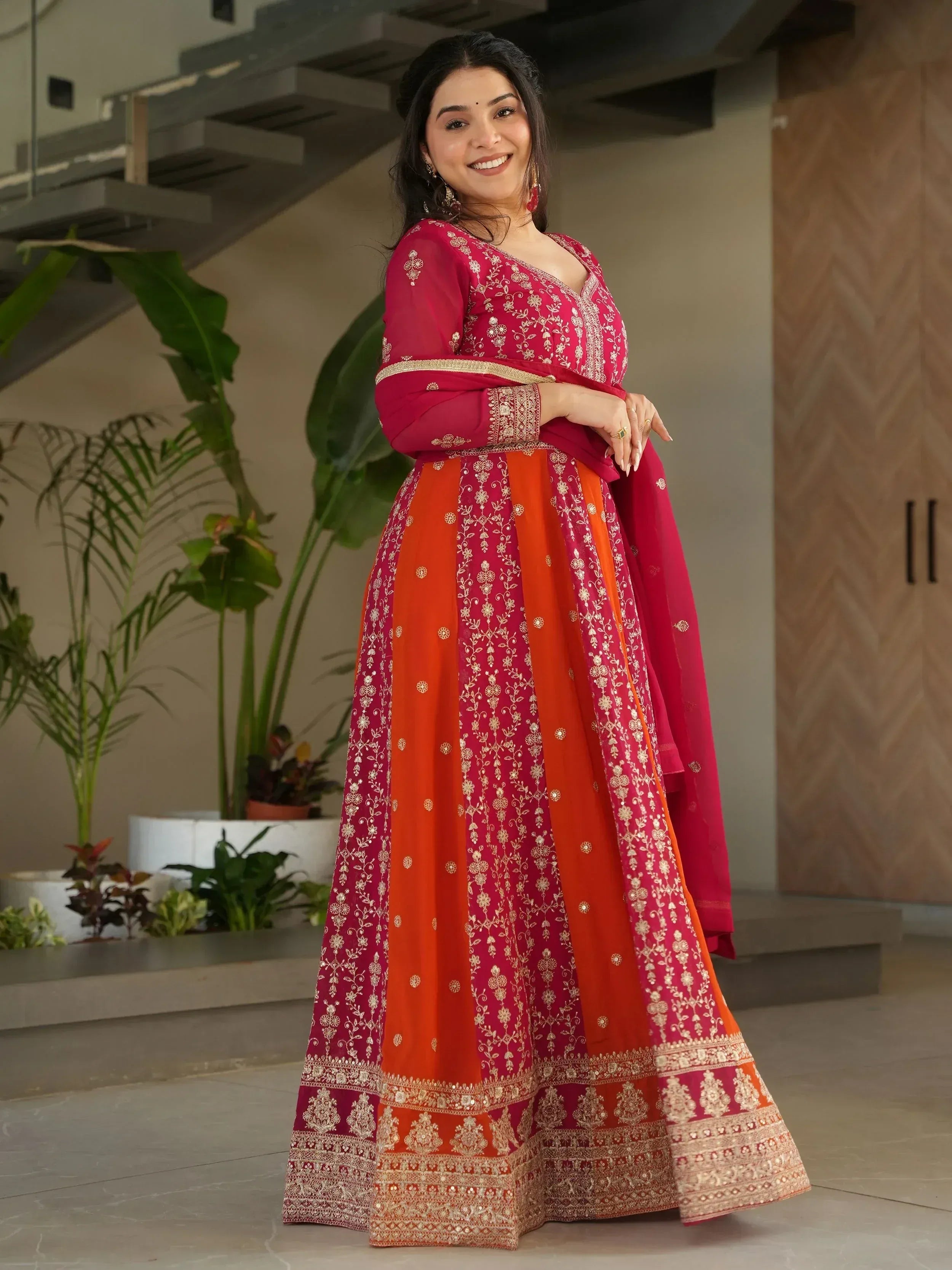 Red and orange embroidered Indian anarkali suit with gold detailing, perfect for festive occasions.