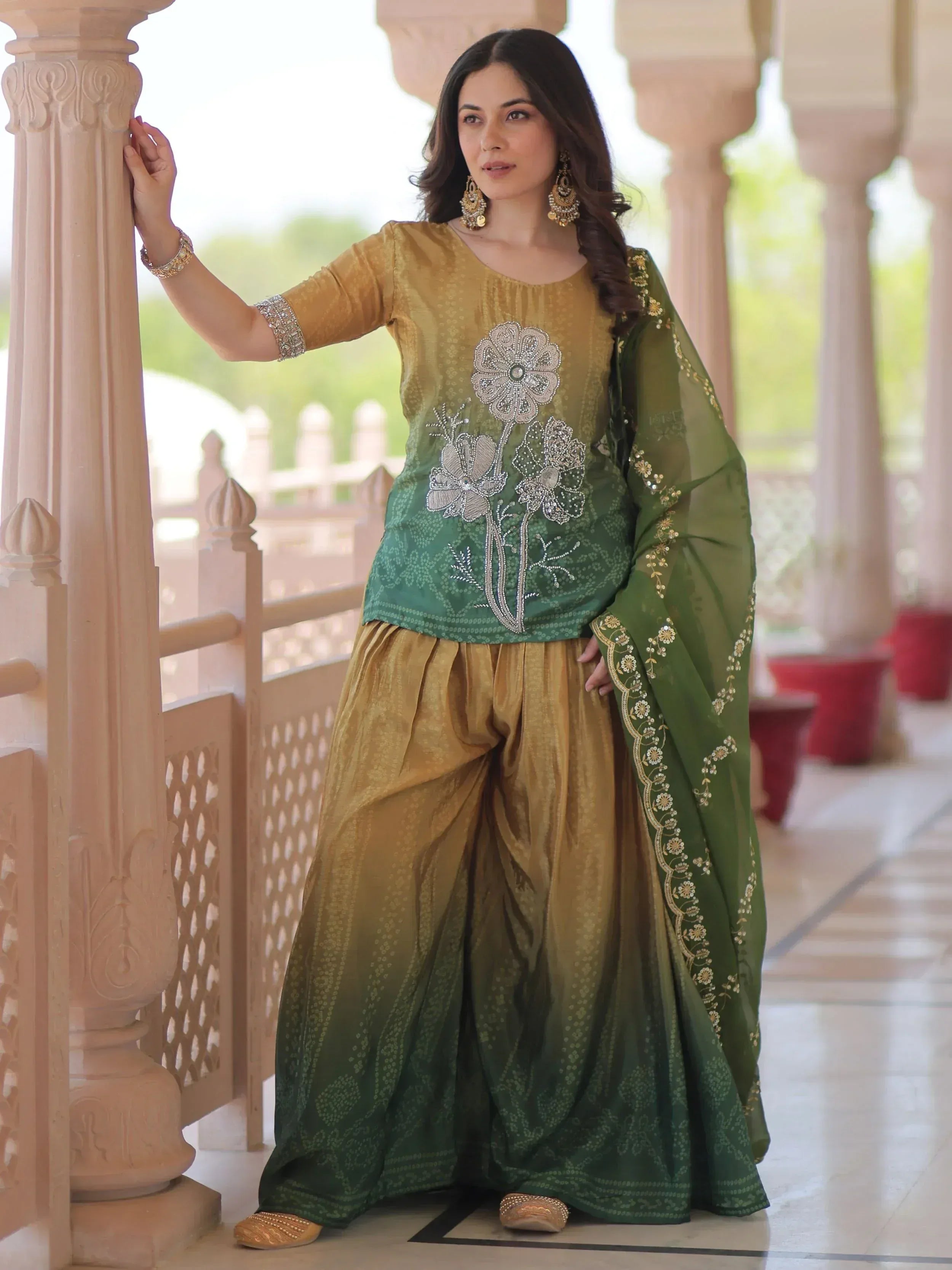 Woman in green and gold embroidered salwar kameez with floral design, traditional Indian ethnic wear
