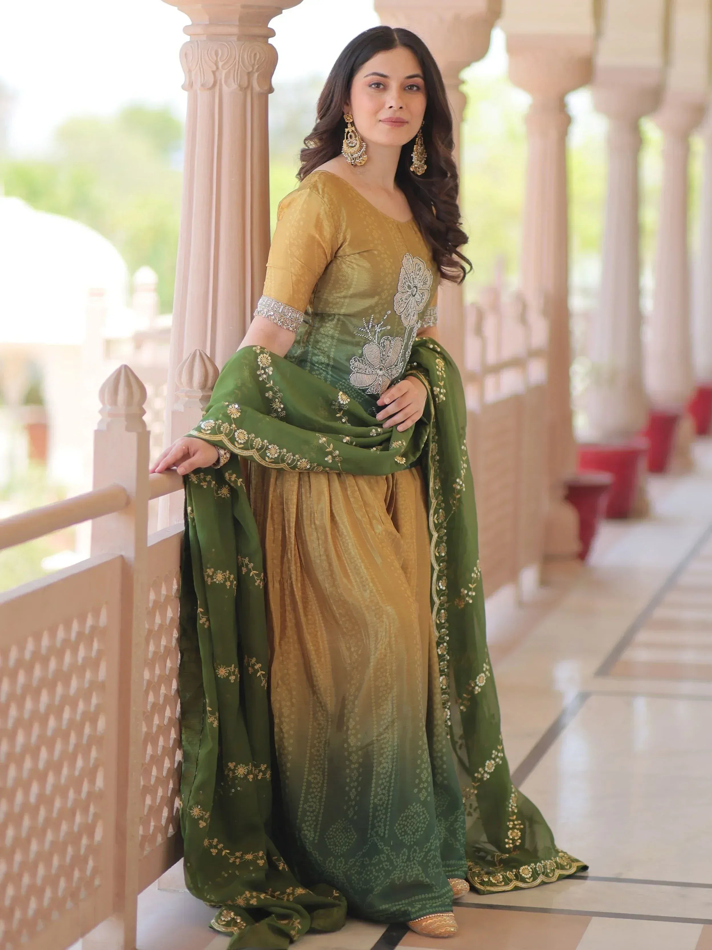 Woman in elegant green and gold ethnic gown with floral embroidery, perfect for Indian occasions