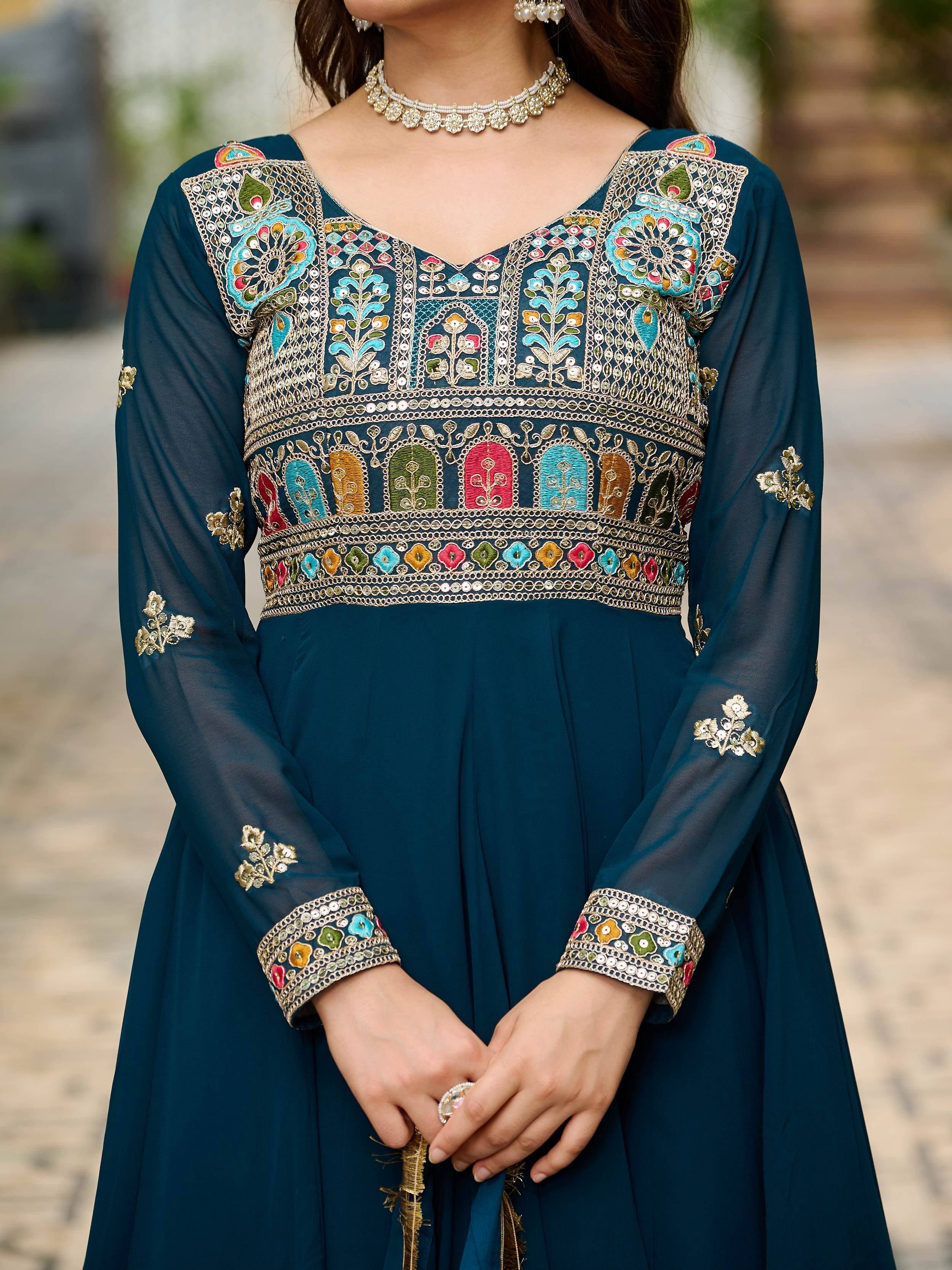 Elegant teal ethnic gown with intricate floral embroidery and mirror work, perfect for festive occasions.