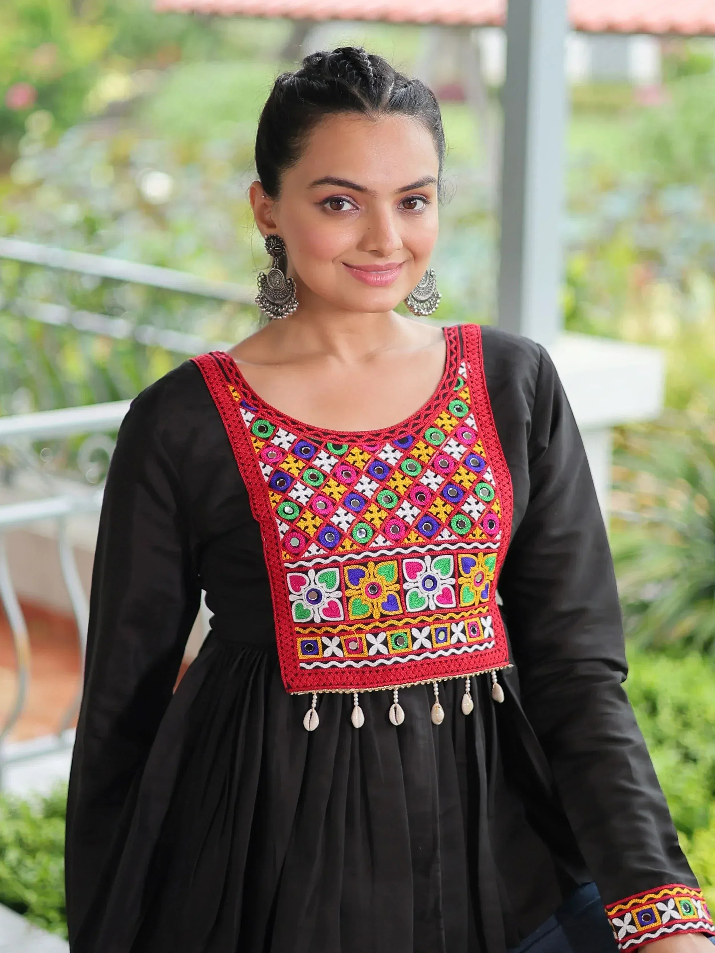 Black ethnic gown with colorful mirror work and shell tassels, perfect for Indian festive wear