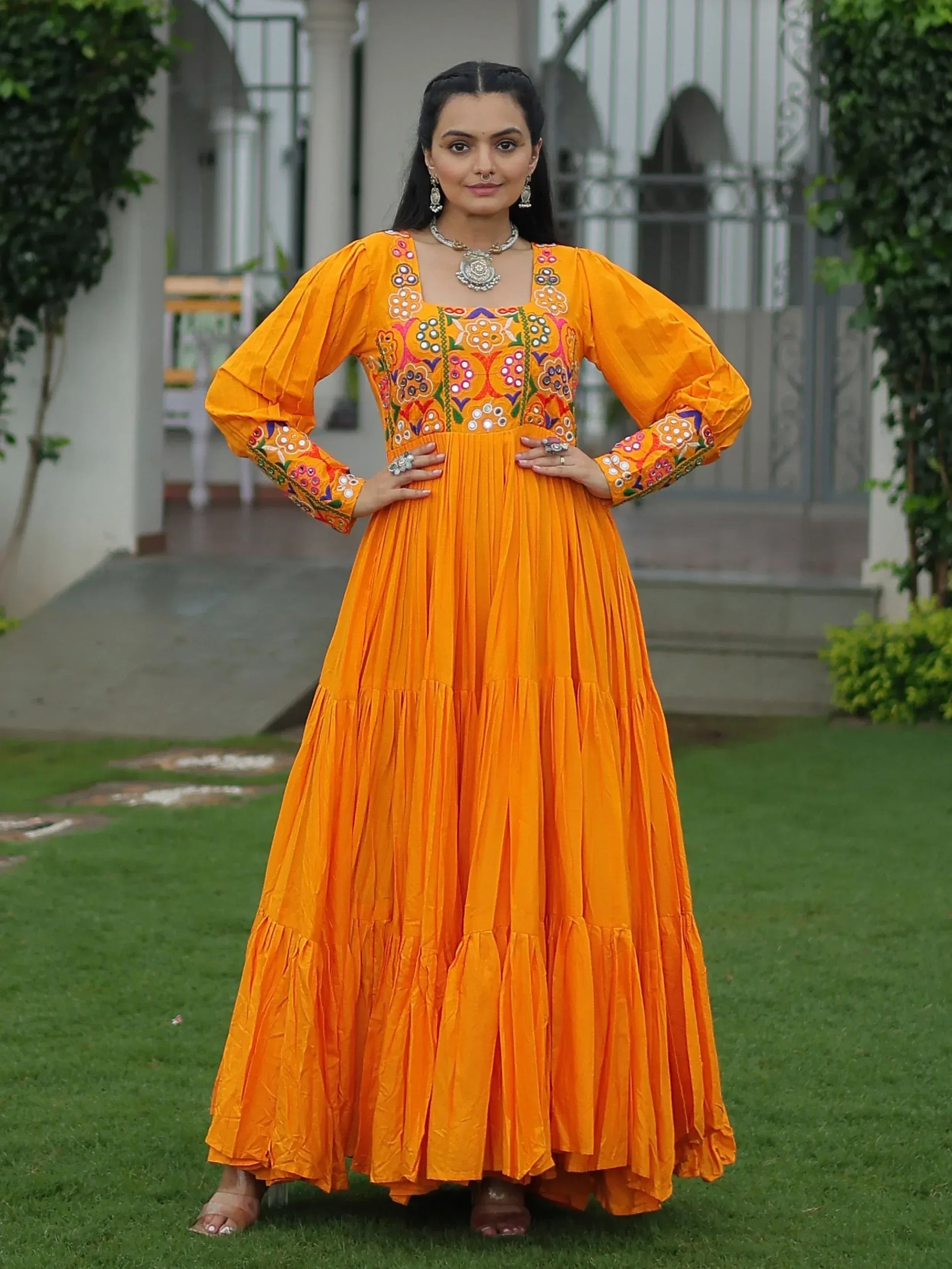 Vibrant orange ethnic gown with floral embroidery, perfect for Indian festive occasions