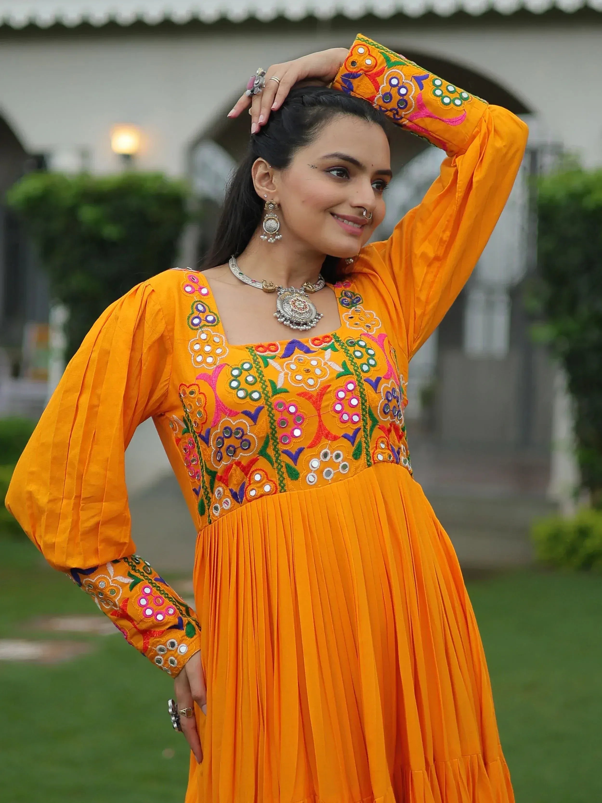Vibrant orange ethnic gown with mirror embroidery, perfect for Indian festivals and occasions