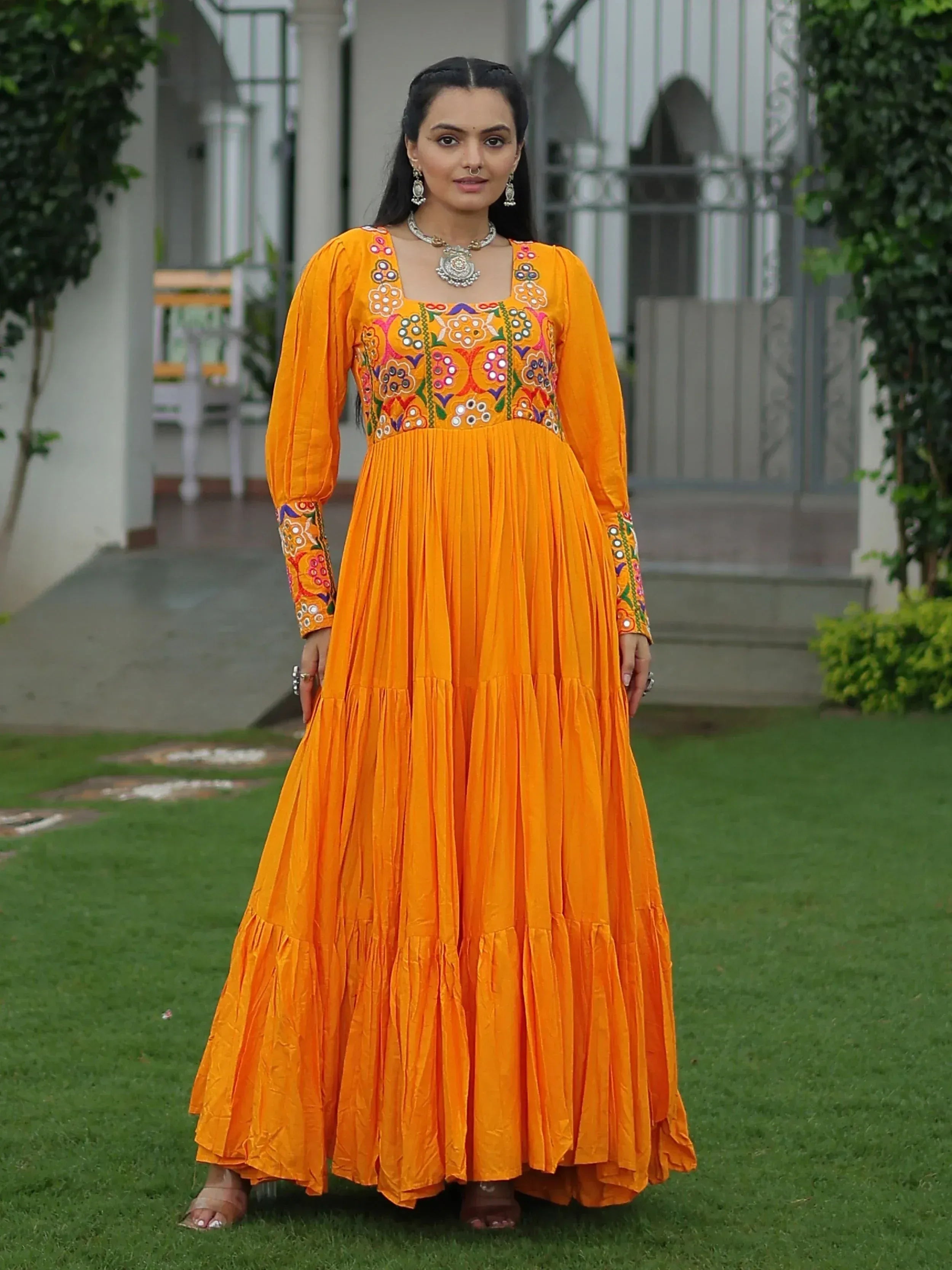 Vibrant orange ethnic gown with floral embroidery, perfect for Indian occasions and festive wear.