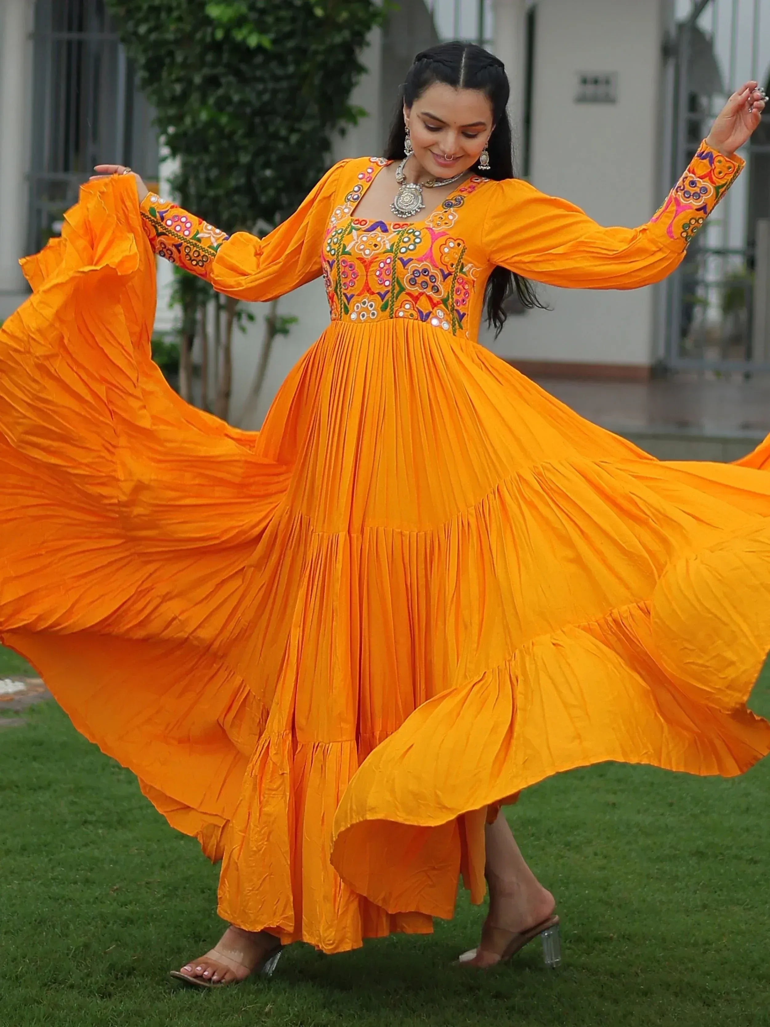 Vibrant orange ethnic gown with floral embroidery, perfect for festive occasions and Indian wear.