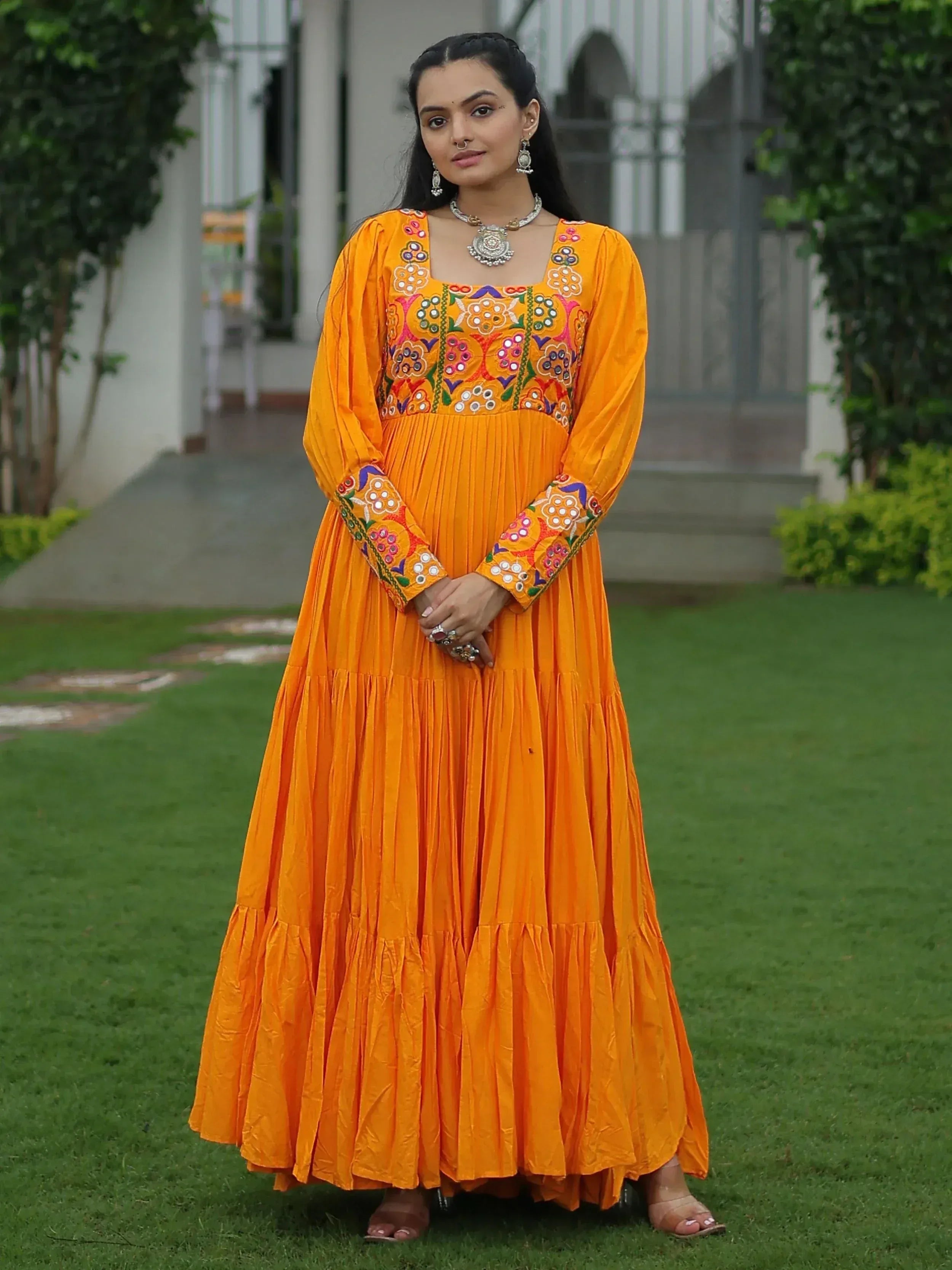 Vibrant orange ethnic gown with colorful mirror embroidery, perfect for Indian festive occasions