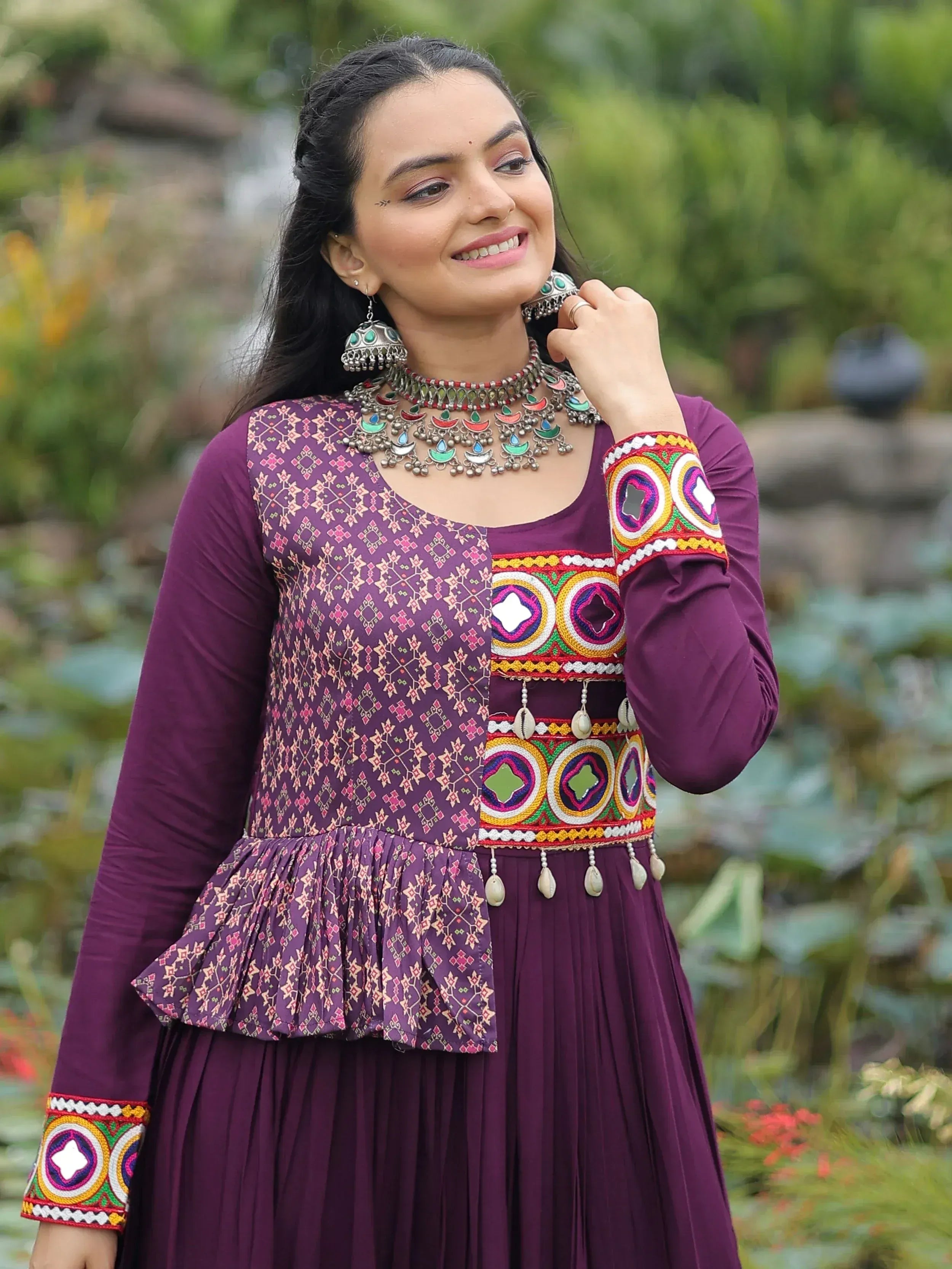 Purple ethnic gown with mirror work, embroidery, and traditional jewelry for Indian wear