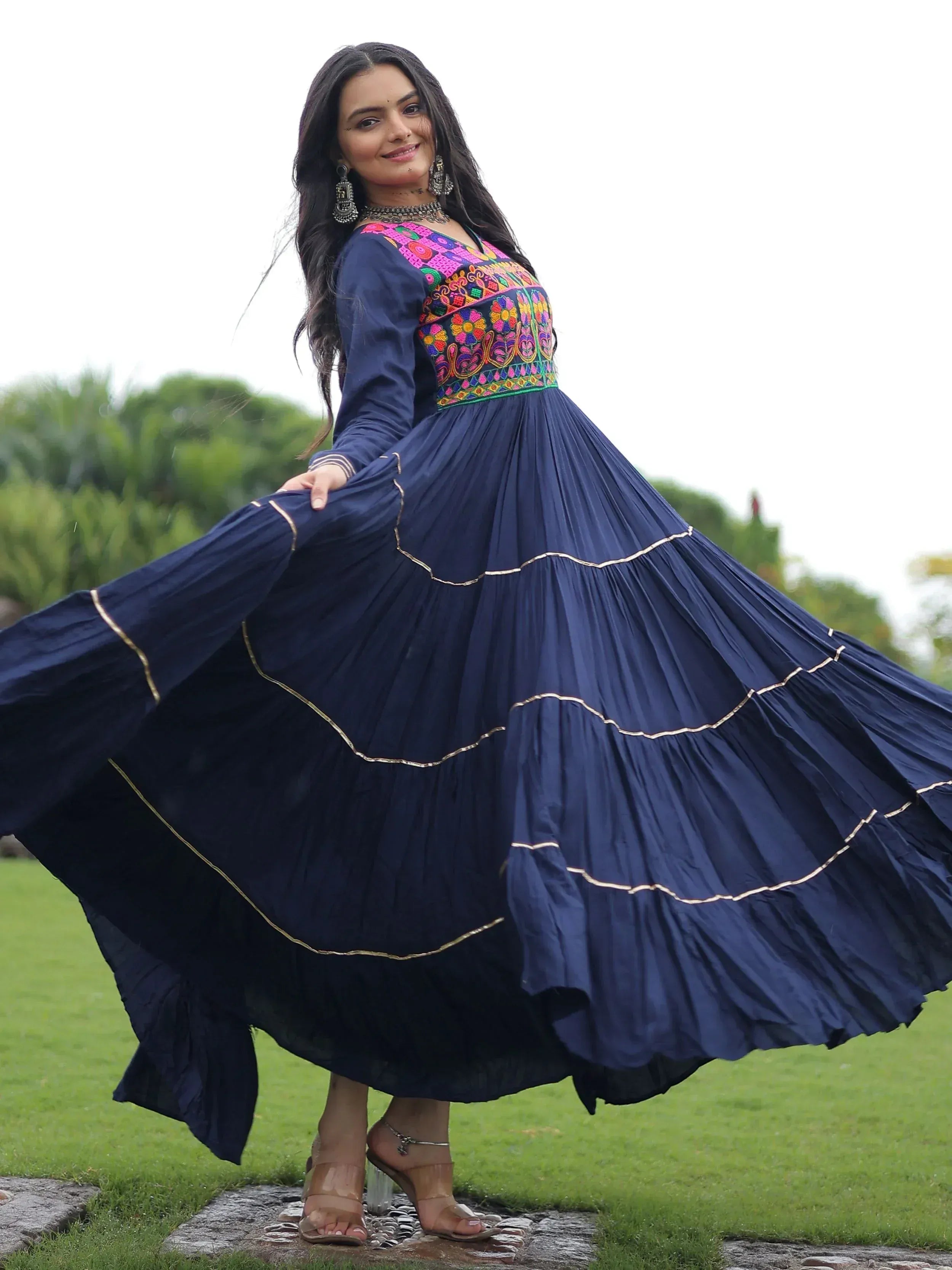 Navy blue ethnic gown with colorful floral embroidery and gold trim, perfect for Indian occasions