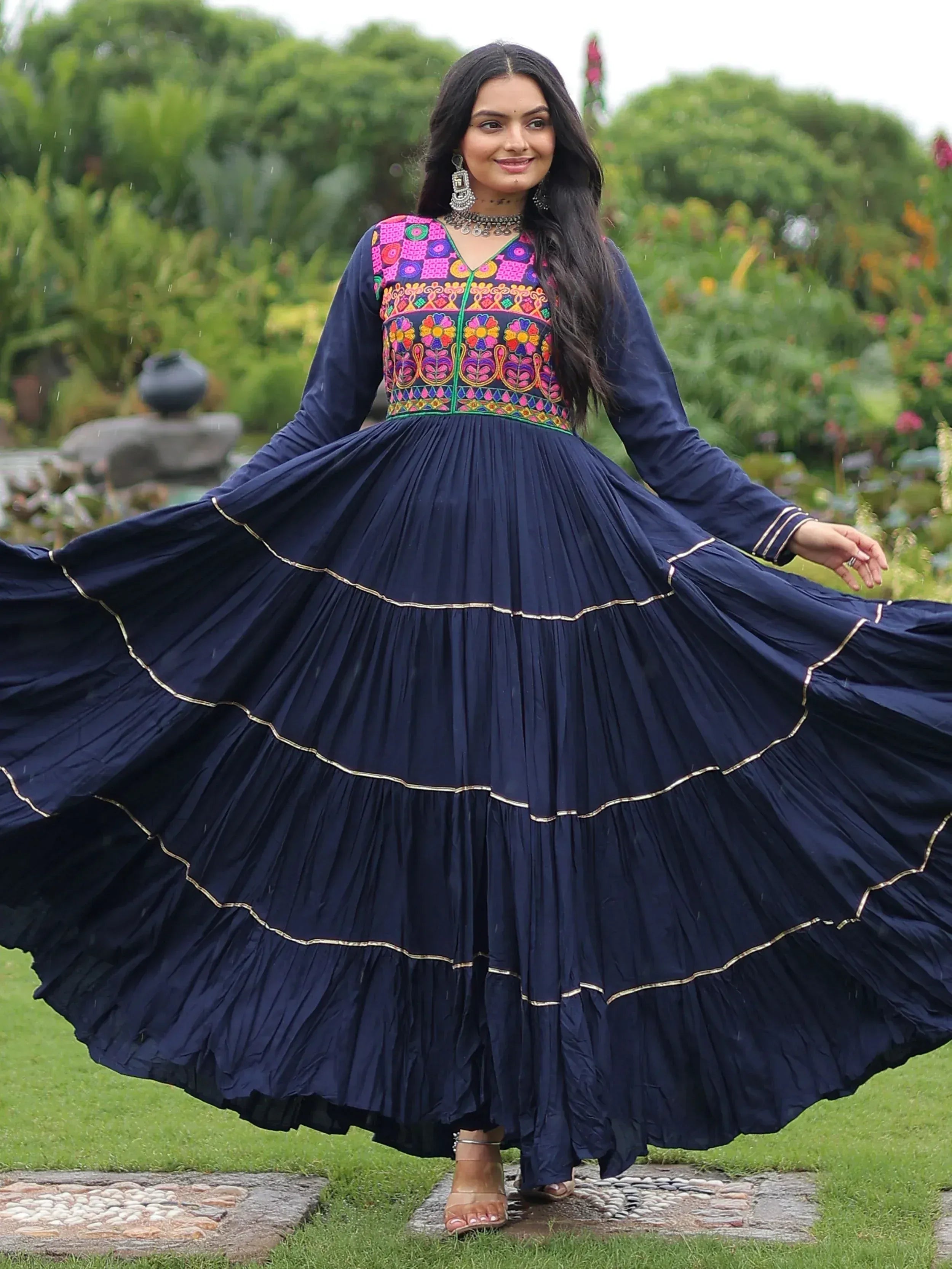Navy blue ethnic gown with vibrant floral embroidery, pleated tiered skirt, perfect for festive occasions