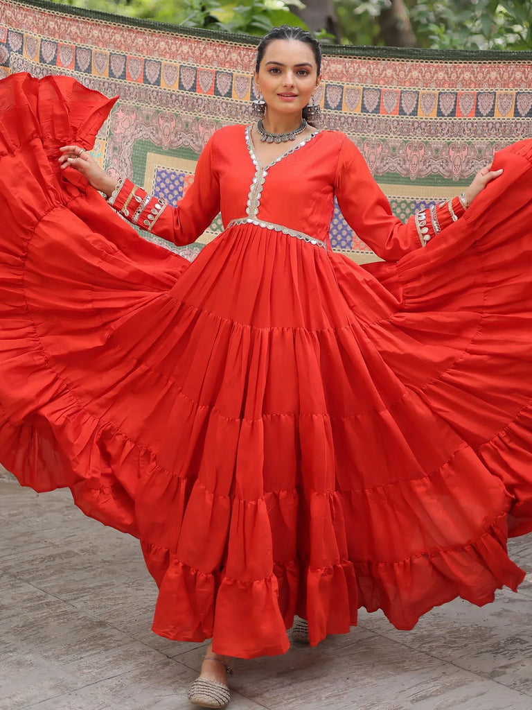 Vibrant red tiered ethnic gown with silver embellishments, perfect for festive occasions.