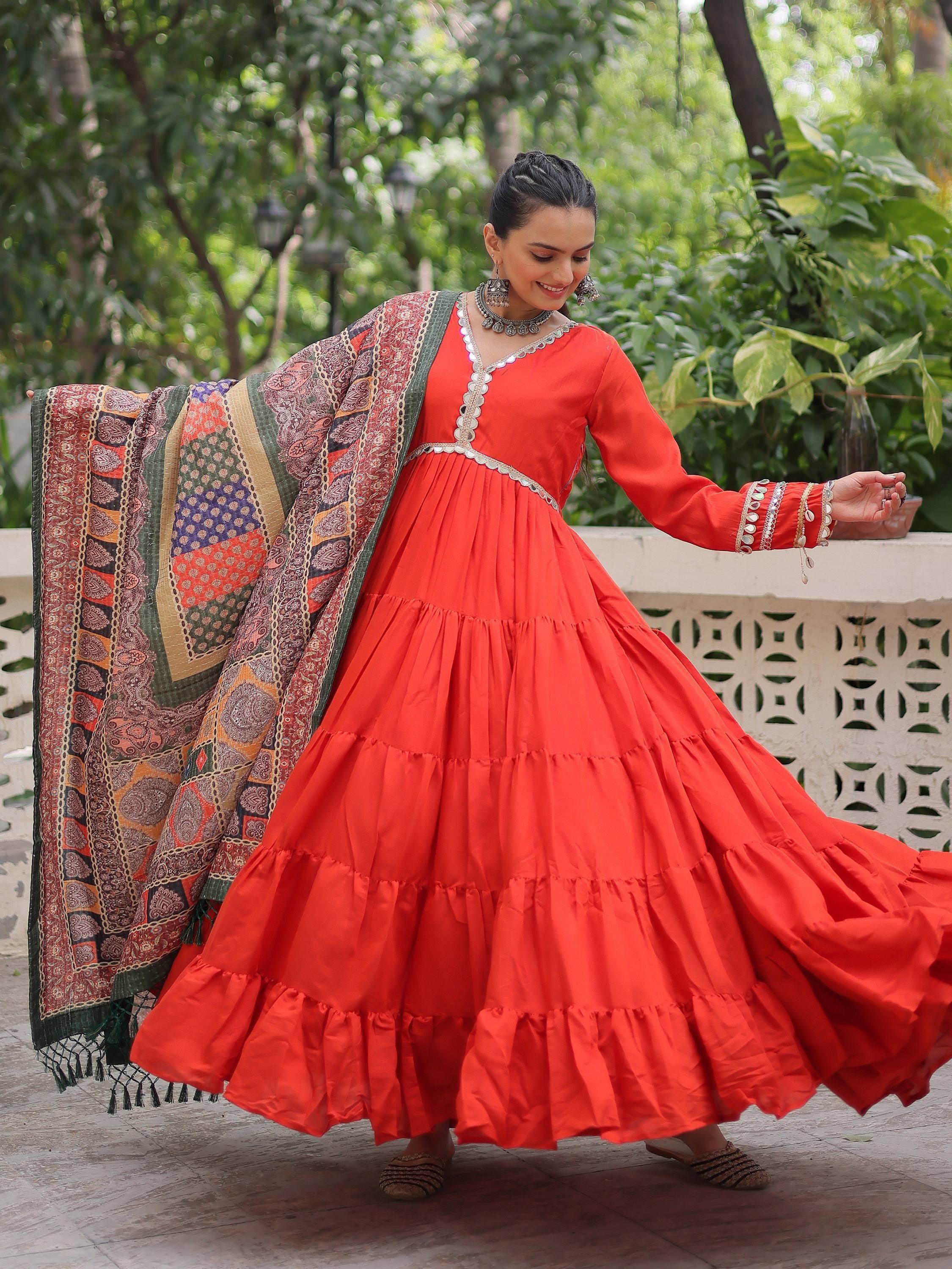 Vibrant red tiered ethnic gown with intricate dupatta, perfect for festive occasions.