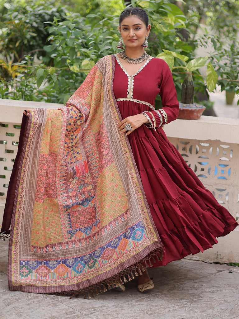 Maroon tiered ethnic gown with mirror work and printed dupatta, perfect for festive occasions