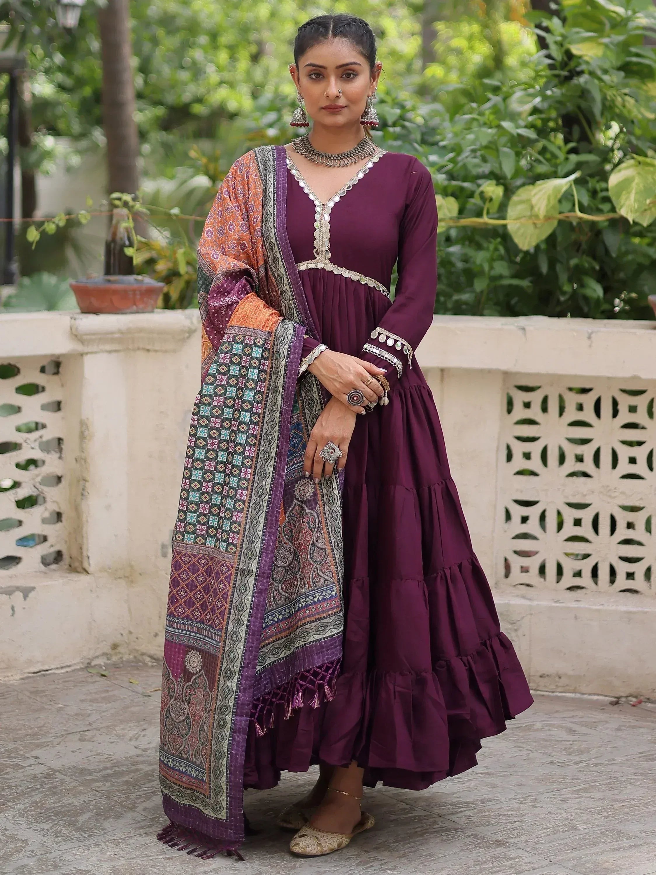 Elegant maroon ethnic gown with intricate embroidery and colorful dupatta, perfect for festive occasions.