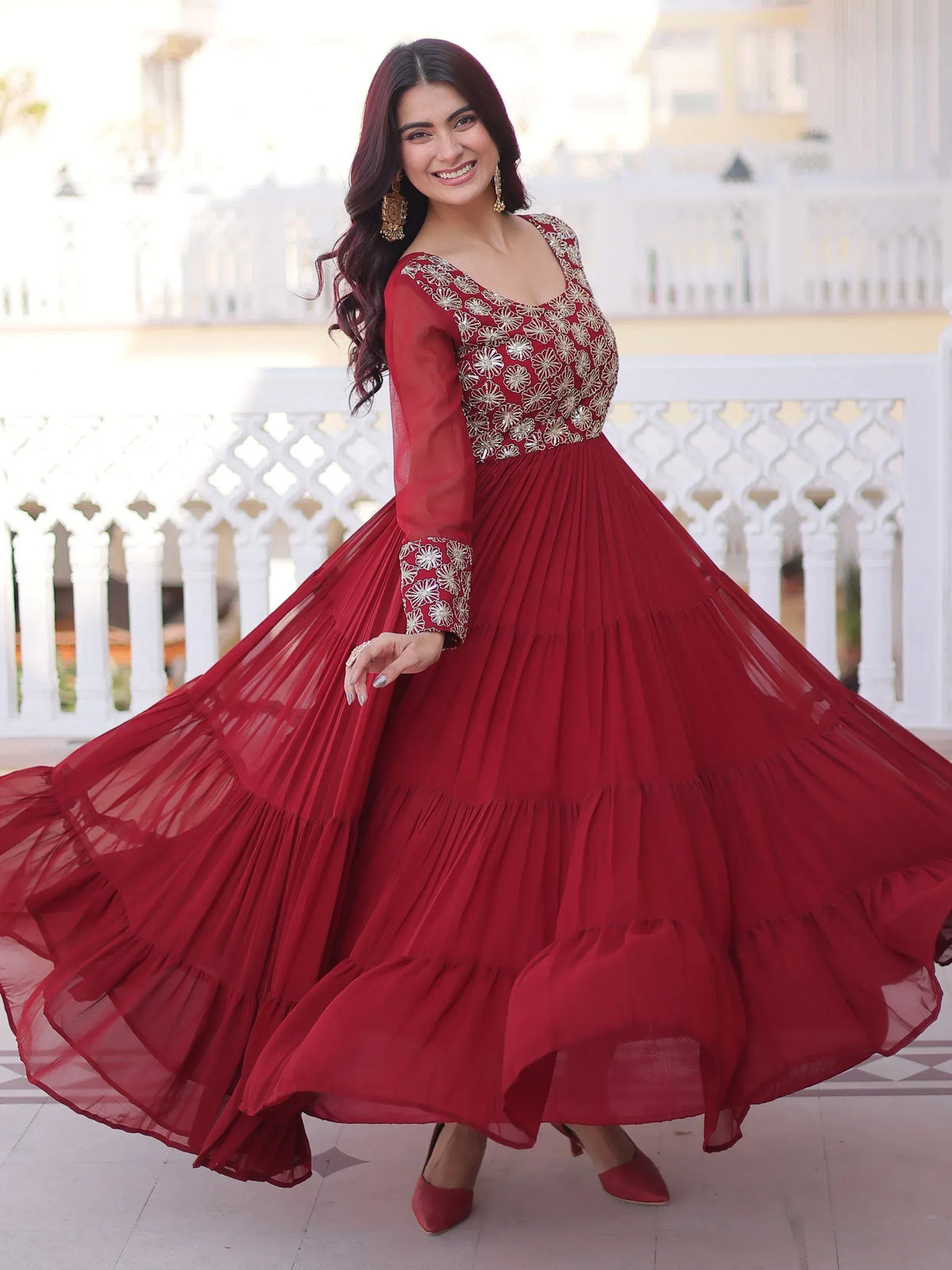 Woman wearing a maroon embroidered ethnic gown with tiered skirt