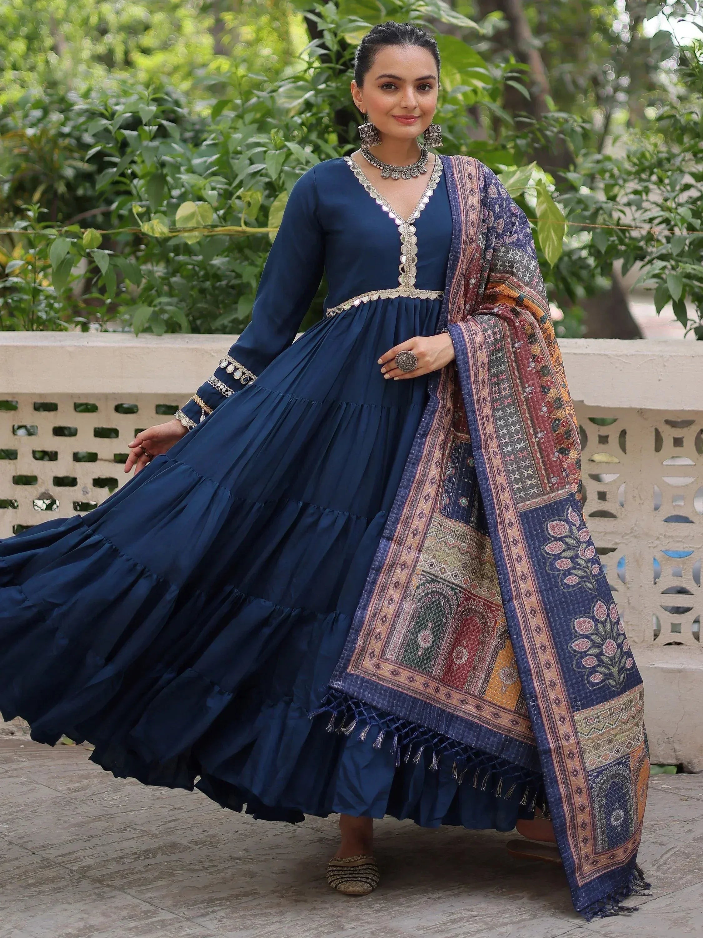 Navy blue tiered Anarkali gown with mirror work and printed dupatta, perfect for ethnic occasions