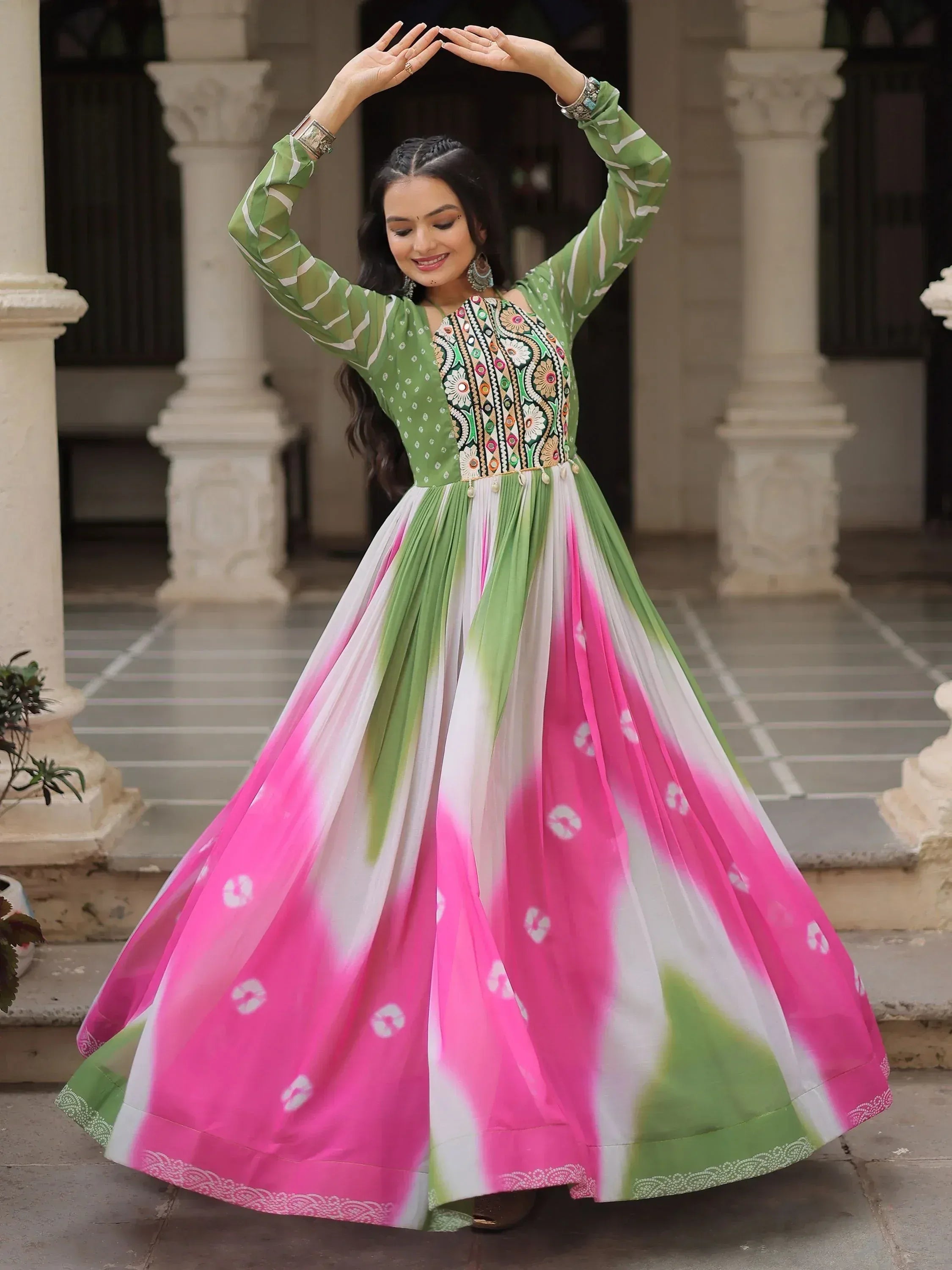 Woman in vibrant green and pink ethnic gown with floral embroidery, perfect for Indian festive occasions.