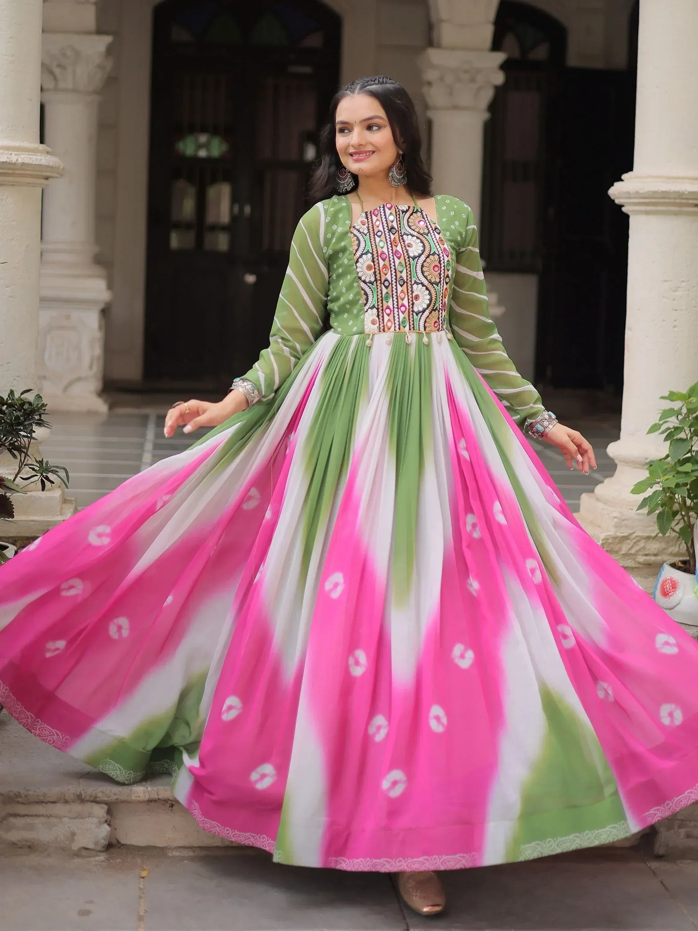 Woman in vibrant green and pink ethnic gown with embroidered bodice, perfect for Indian festive occasions.