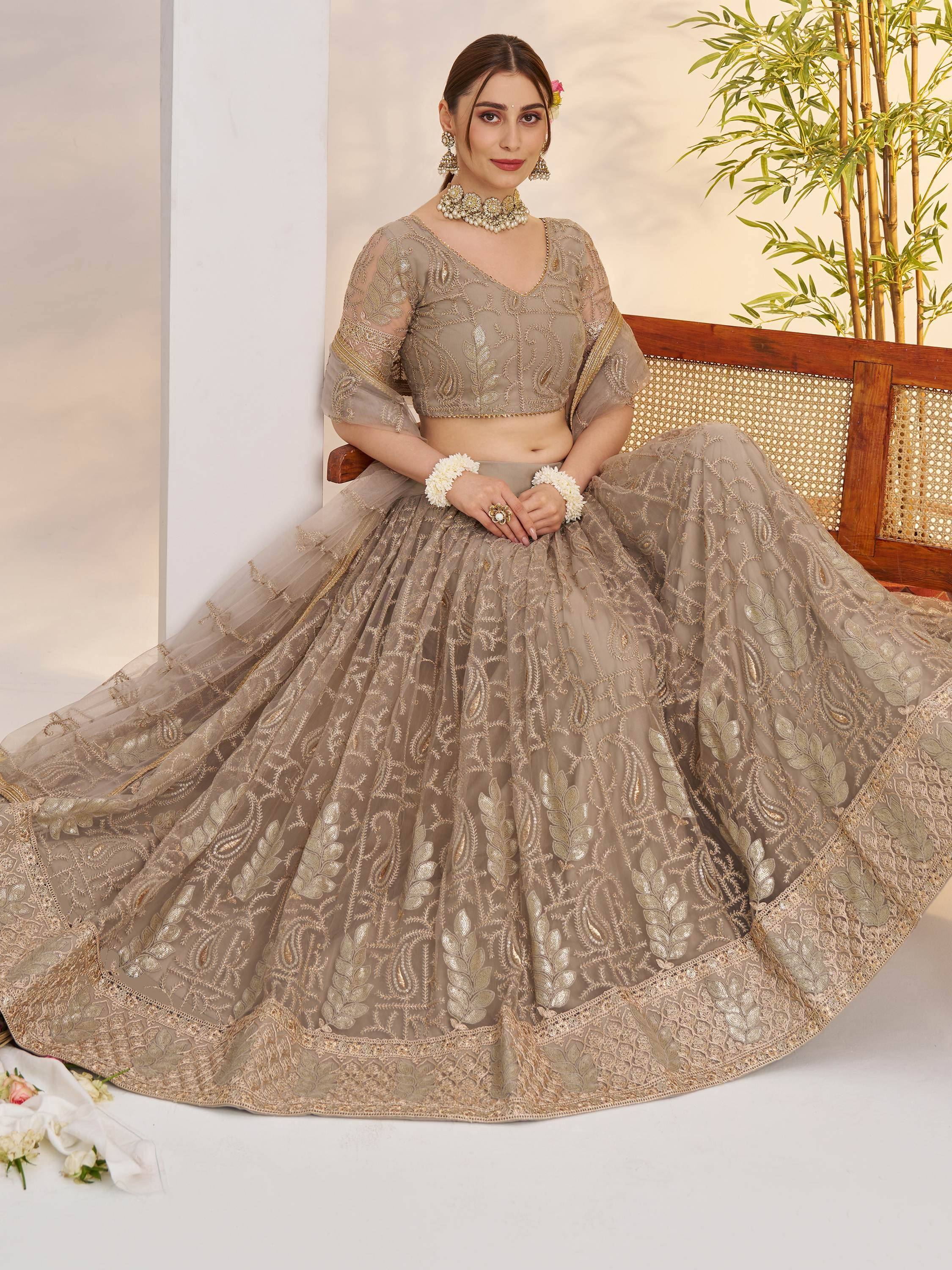 Elegant beige embroidered lehenga choli with gold detailing, perfect for Indian weddings and festive occasions.
