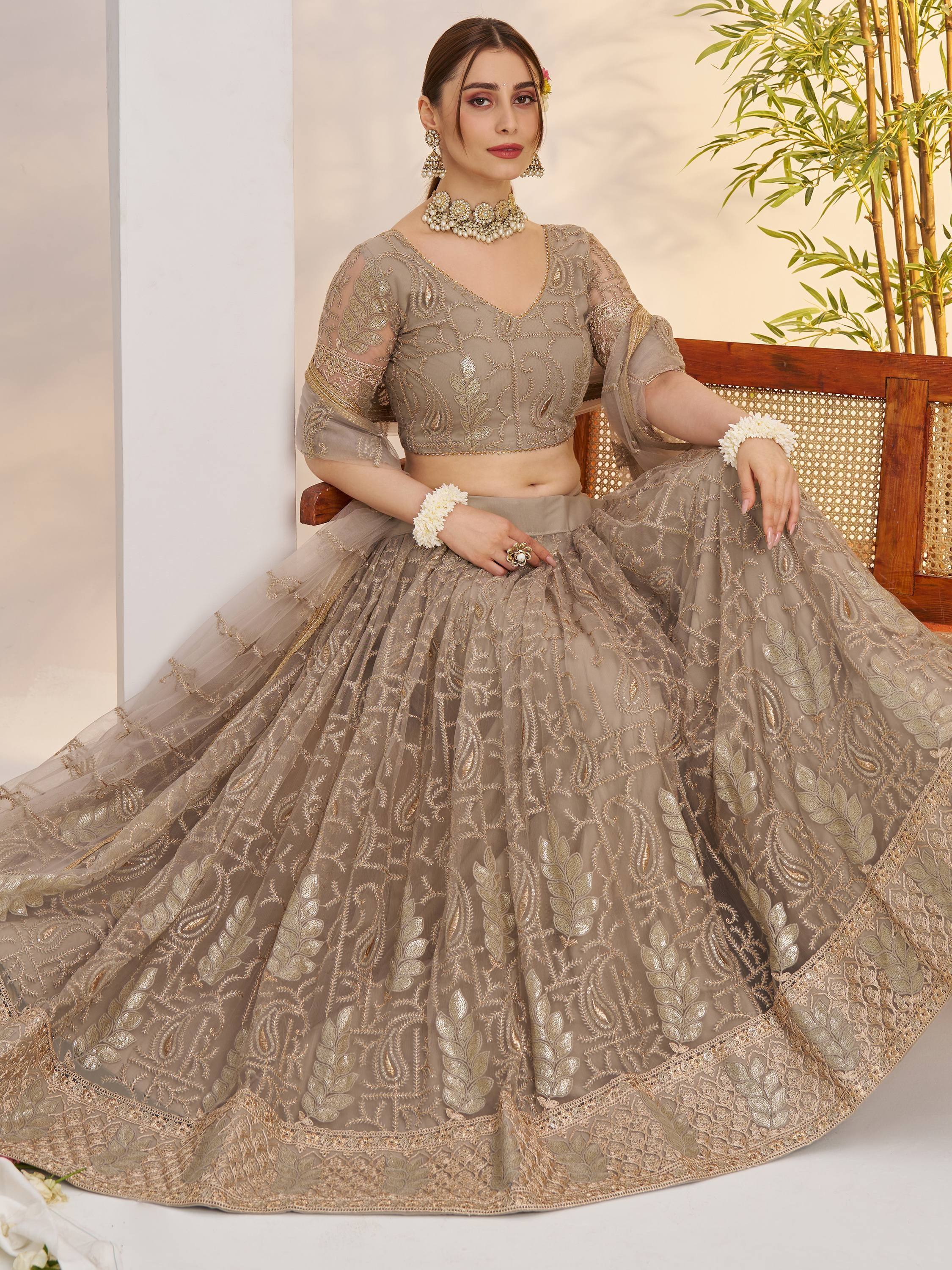 Elegant beige embroidered lehenga choli with gold floral work, perfect for Indian weddings and festive occasions.