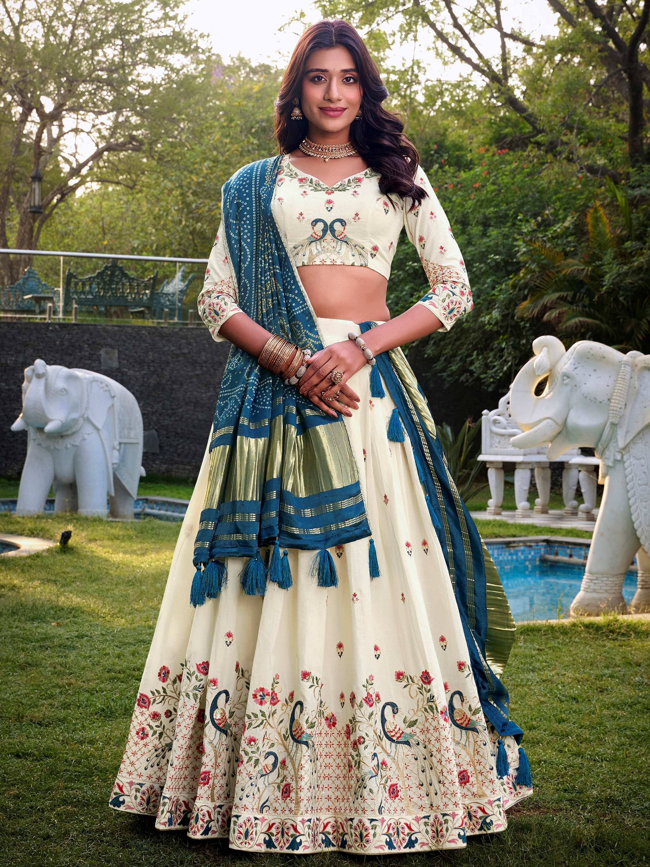 Cream floral lehenga choli with peacock embroidery, blue dupatta, garden setting