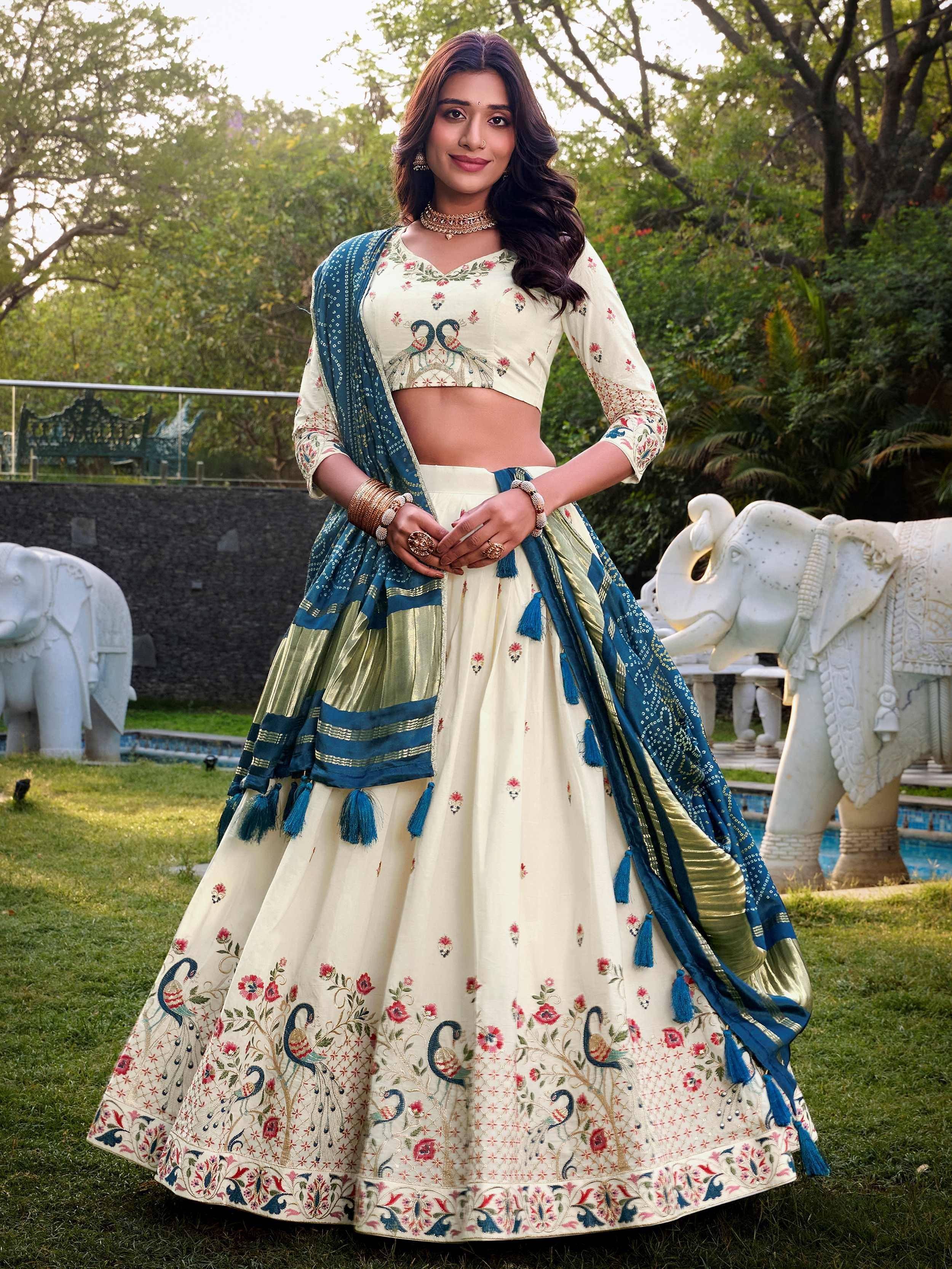 Cream lehenga choli with peacock embroidery, blue dupatta, floral motifs, perfect for Indian weddings or festivals