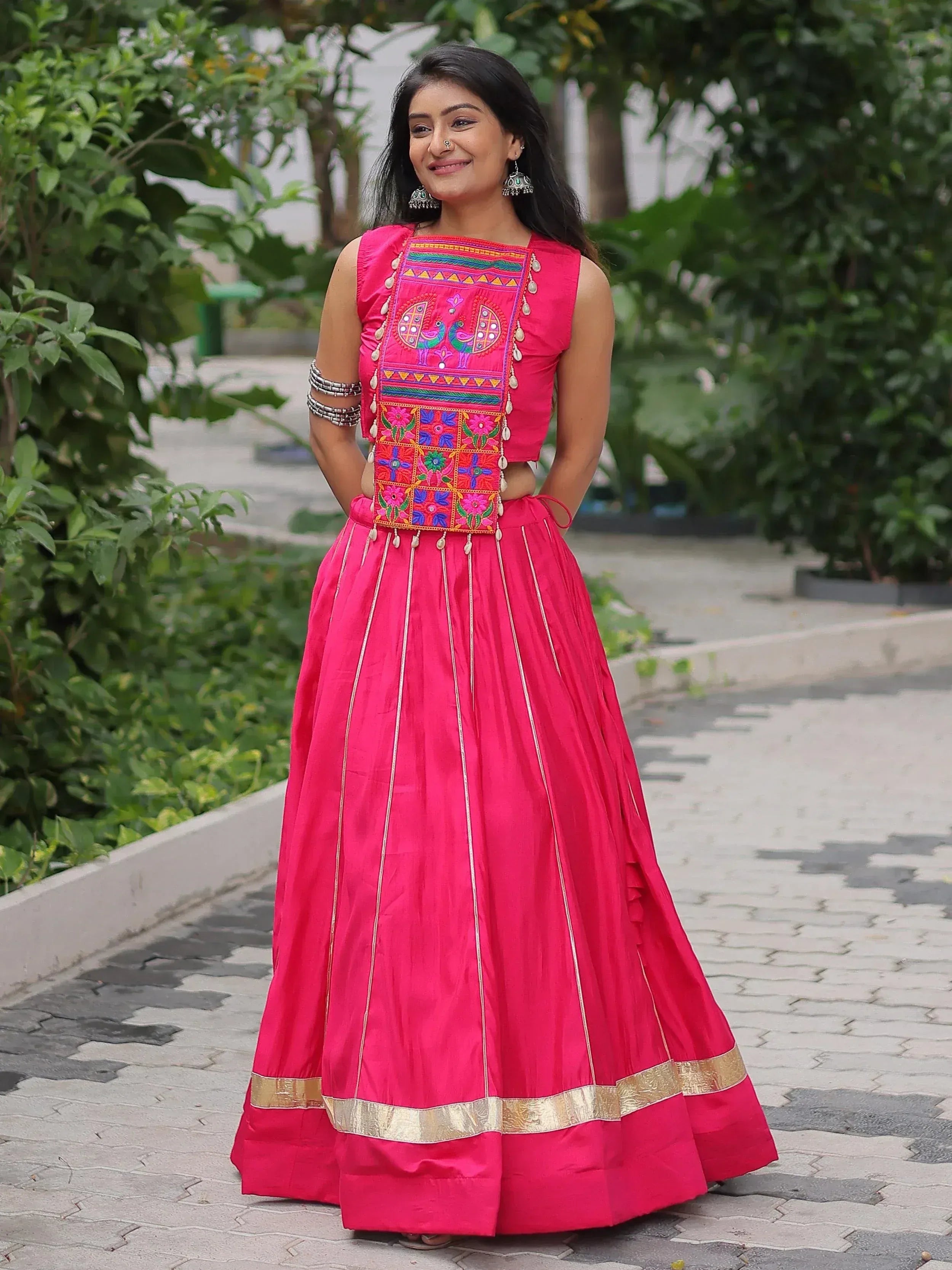 Pink embroidered lehenga choli with peacock motifs, gold border, and mirror work for Indian ethnic wear