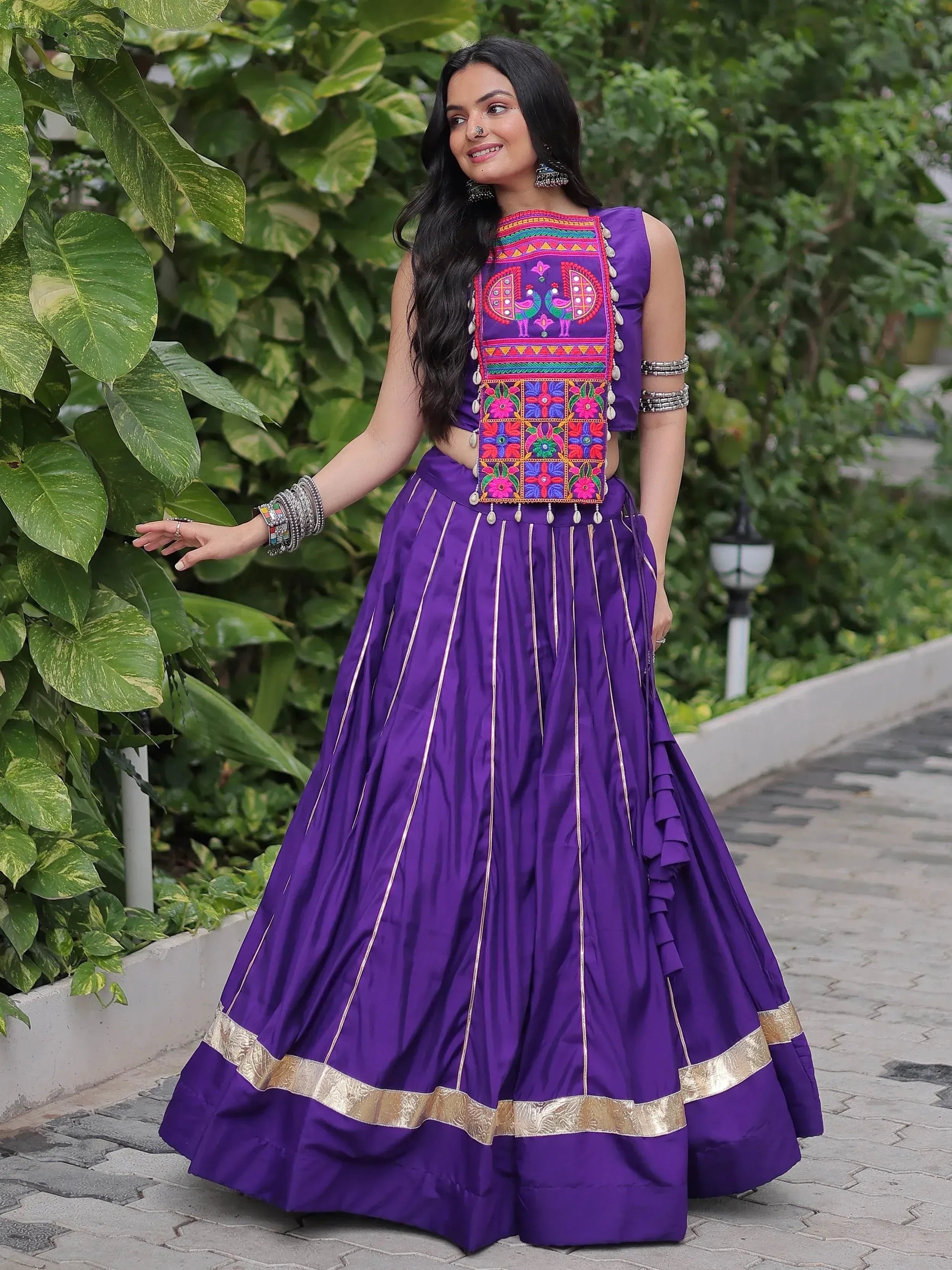 Purple embroidered lehenga choli with peacock motifs, gold trim, and ruffled skirt for ethnic wear