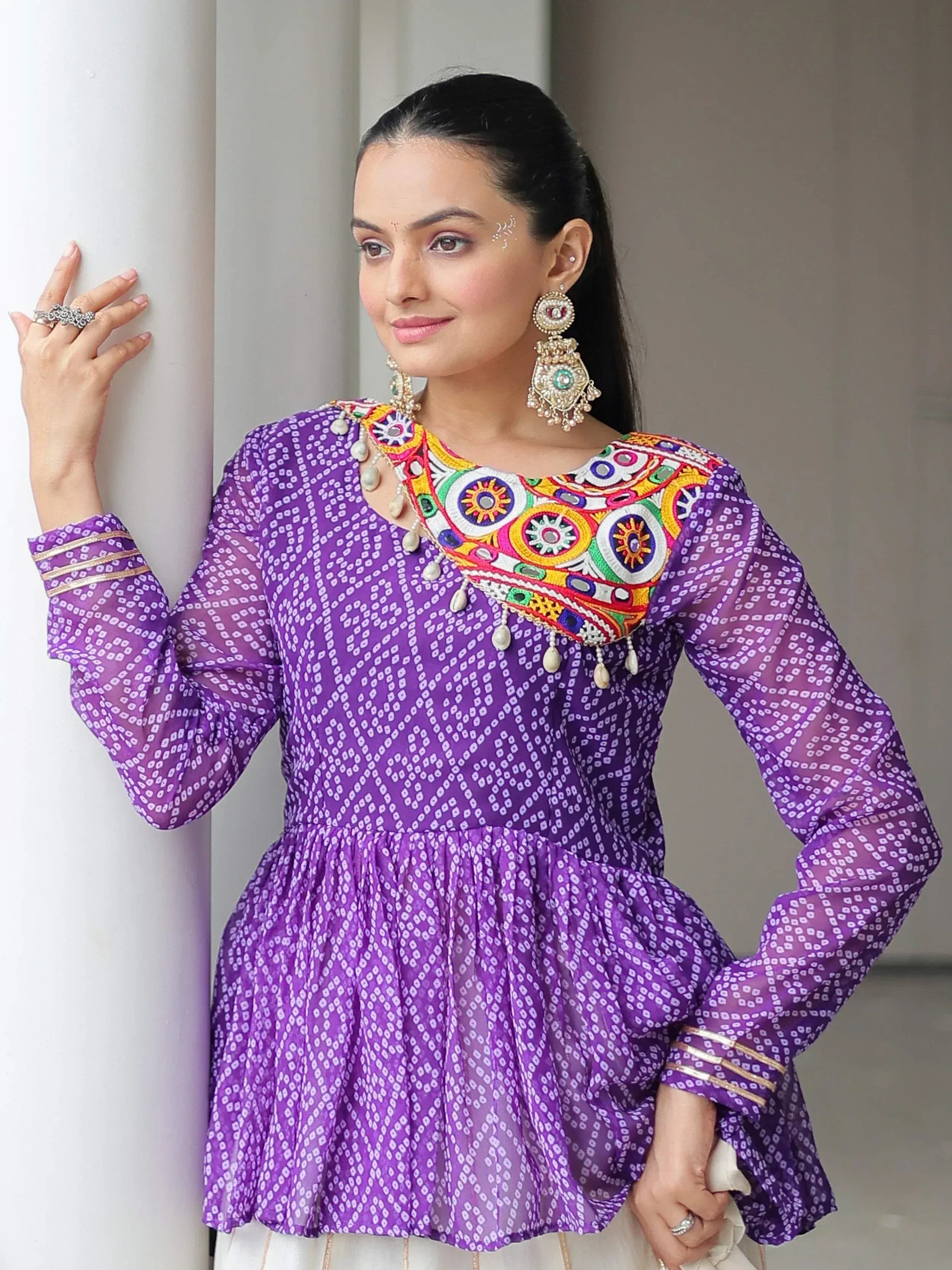 Purple ethnic kurta with colorful mirror work neckline and sheer sleeves, paired with traditional jewelry