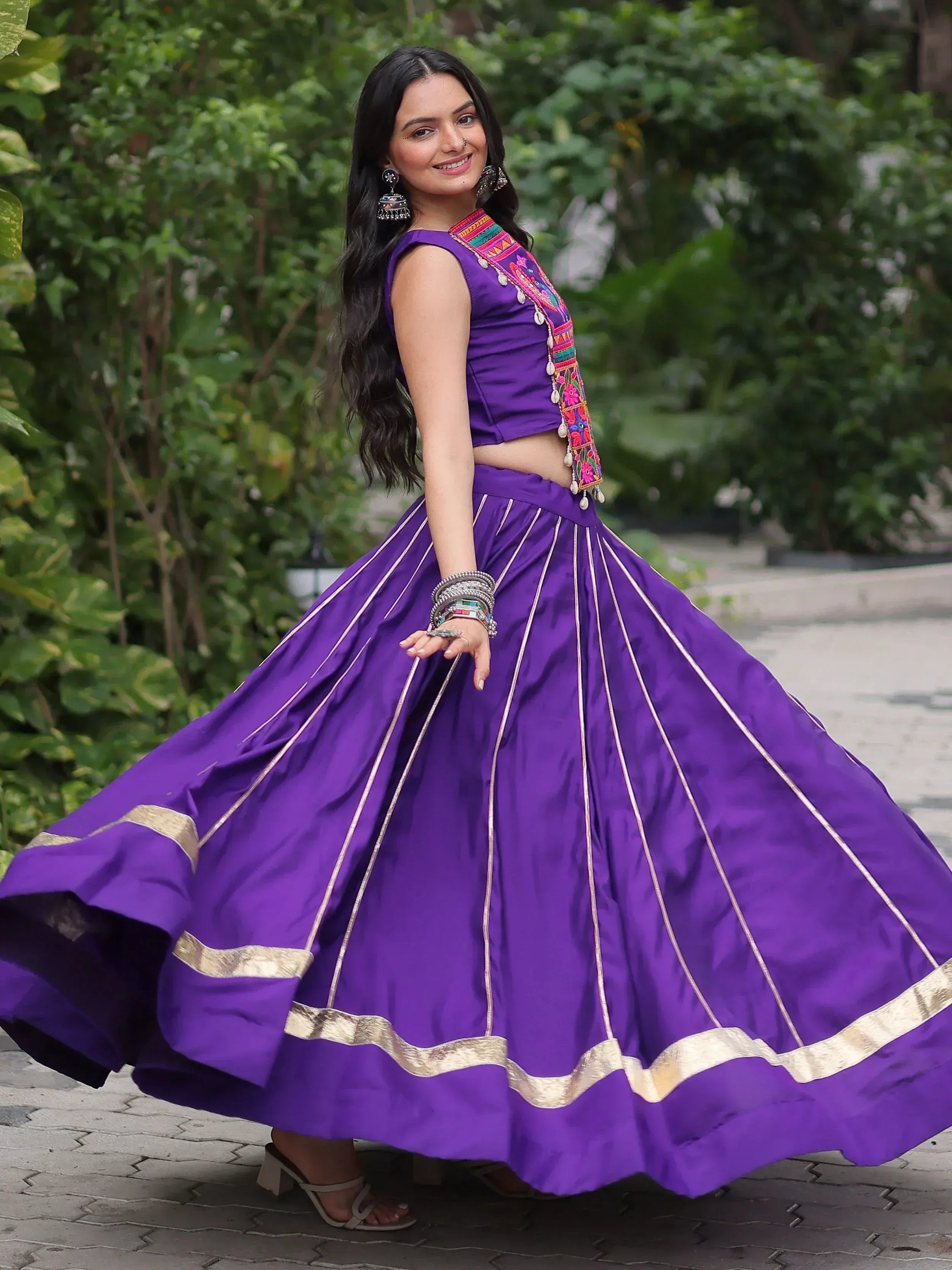Purple ethnic lehenga choli with gold trim and embroidered blouse, perfect for festive occasions.