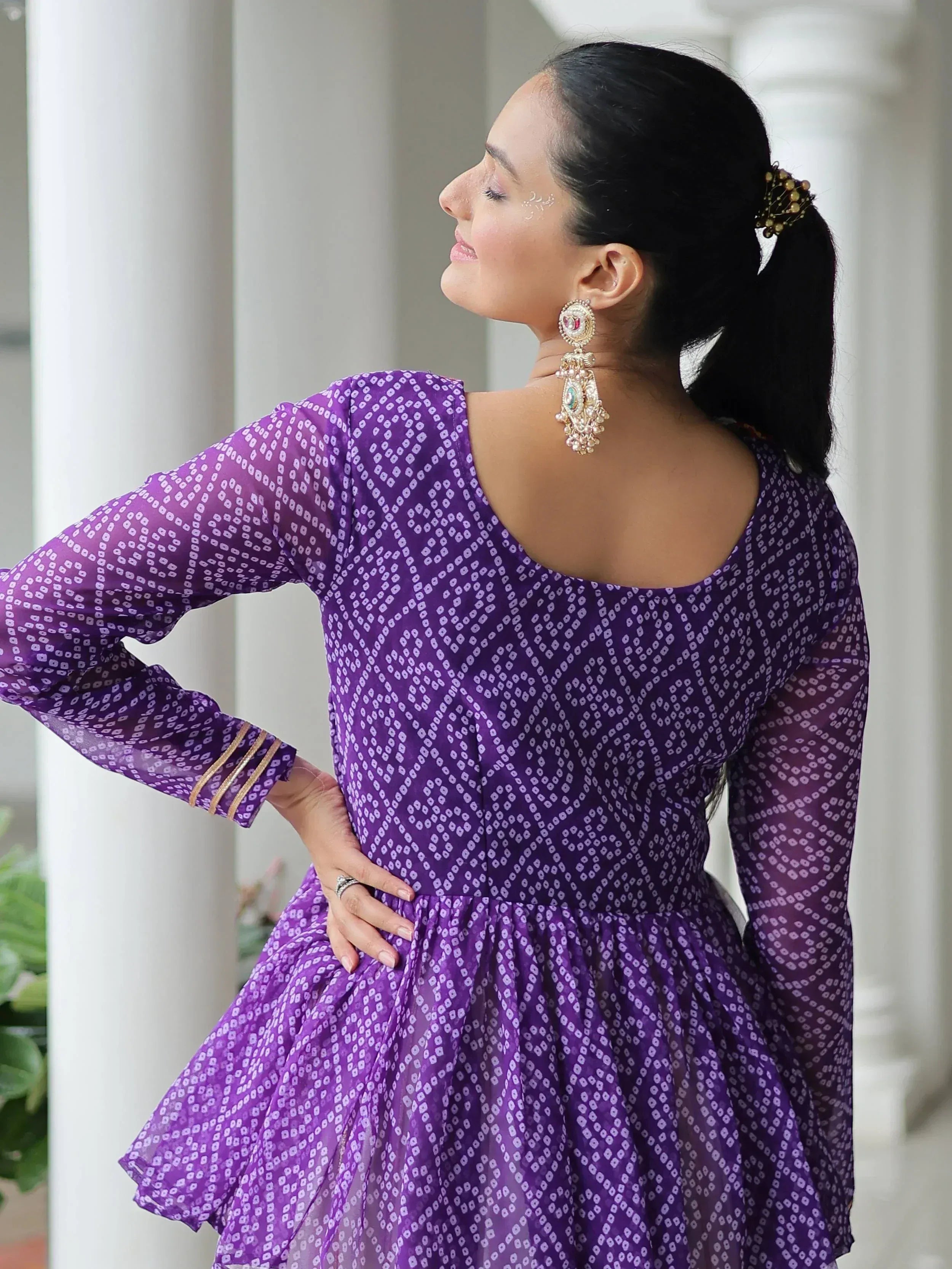 Purple printed ethnic gown with back cutout, gold trim sleeves, and statement earrings for Indian wear