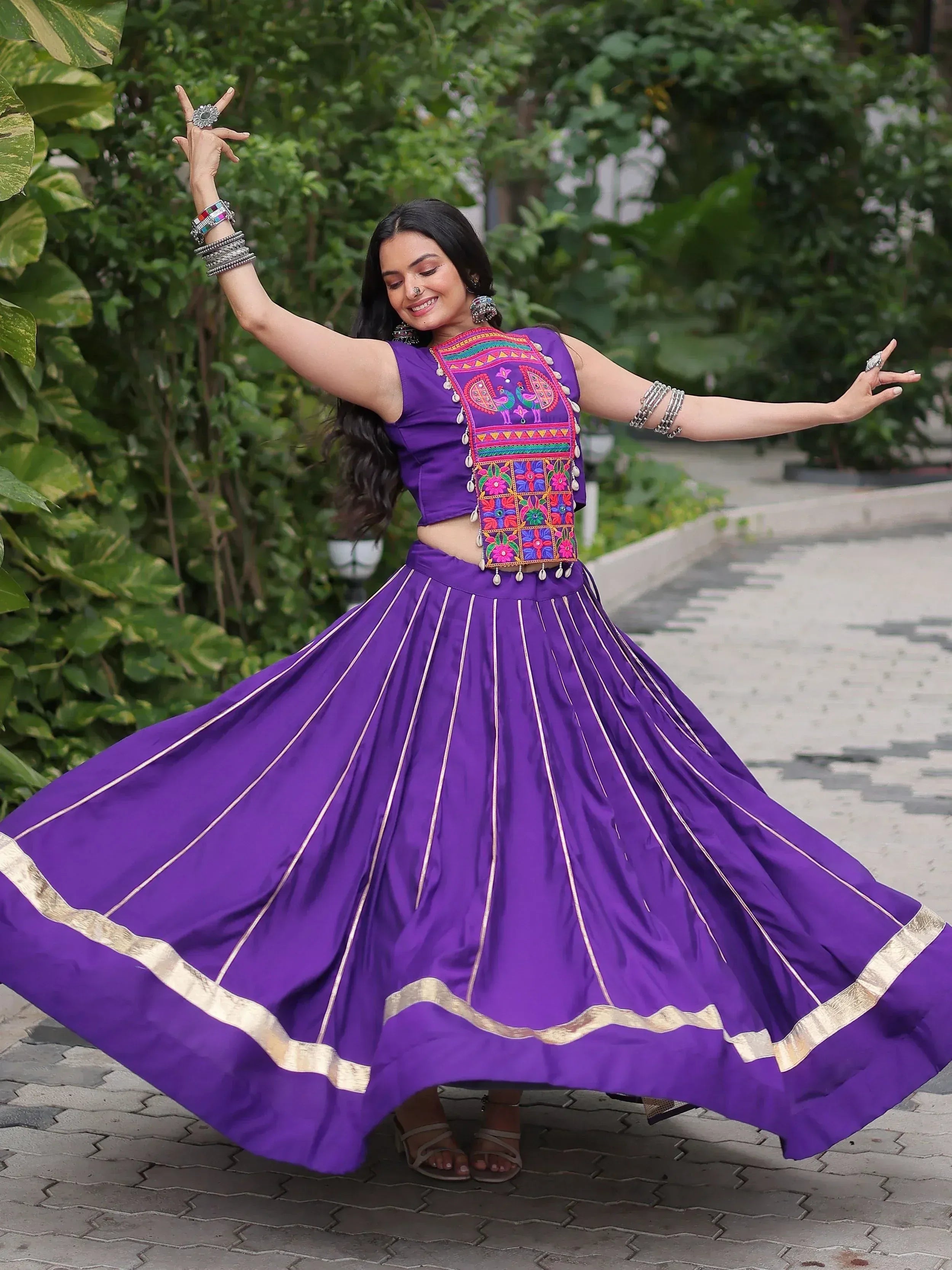 Purple ethnic lehenga with embroidered blouse, gold trim, and flared skirt for festive occasions