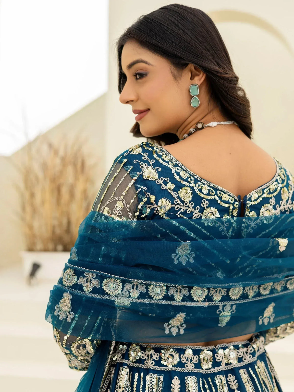 Teal blue embroidered lehenga choli with sheer sleeves and floral zari work, perfect for Indian ethnic wear.