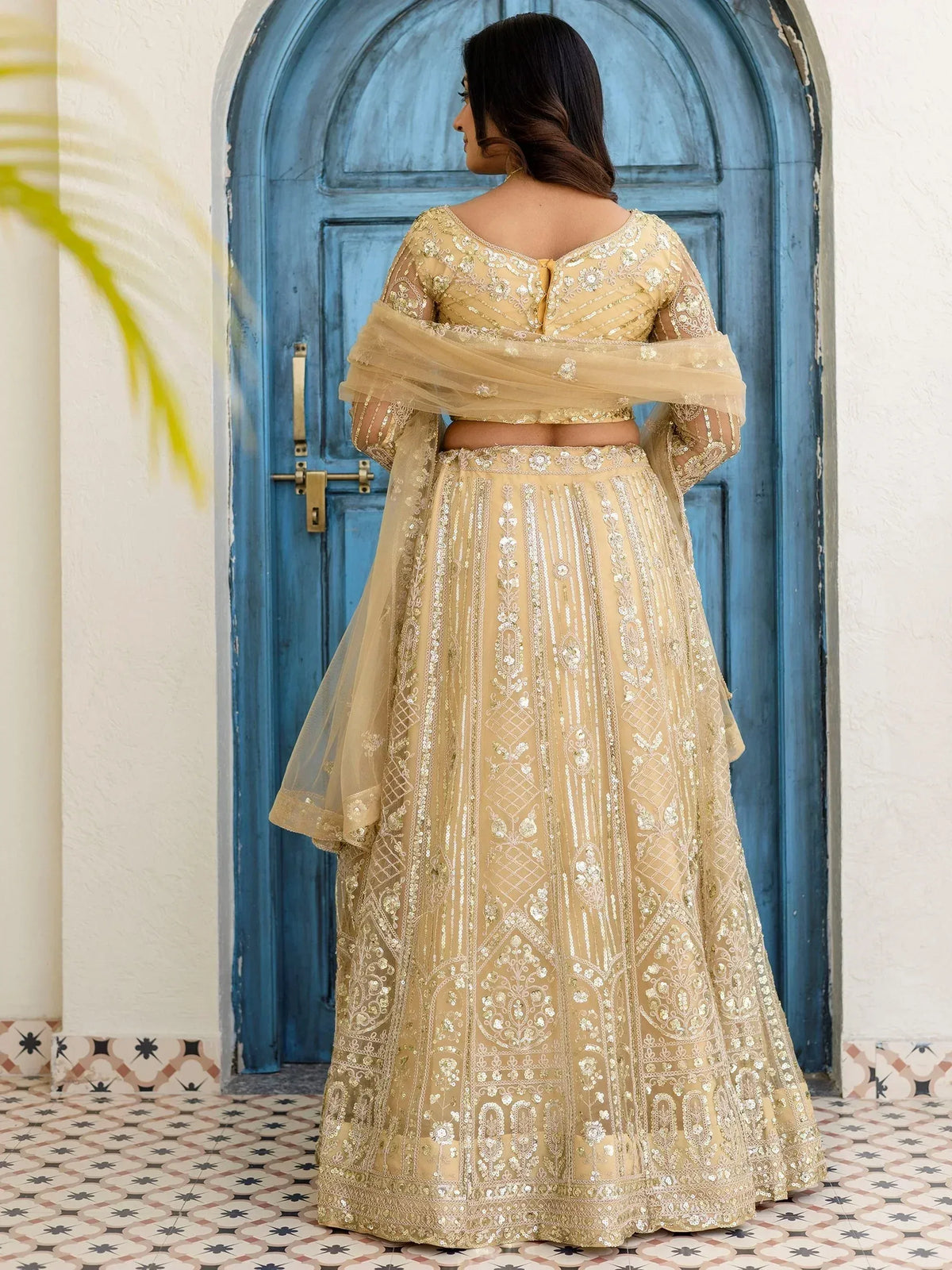 Elegant beige lehenga choli with intricate gold embroidery, perfect for Indian ethnic wear occasions.