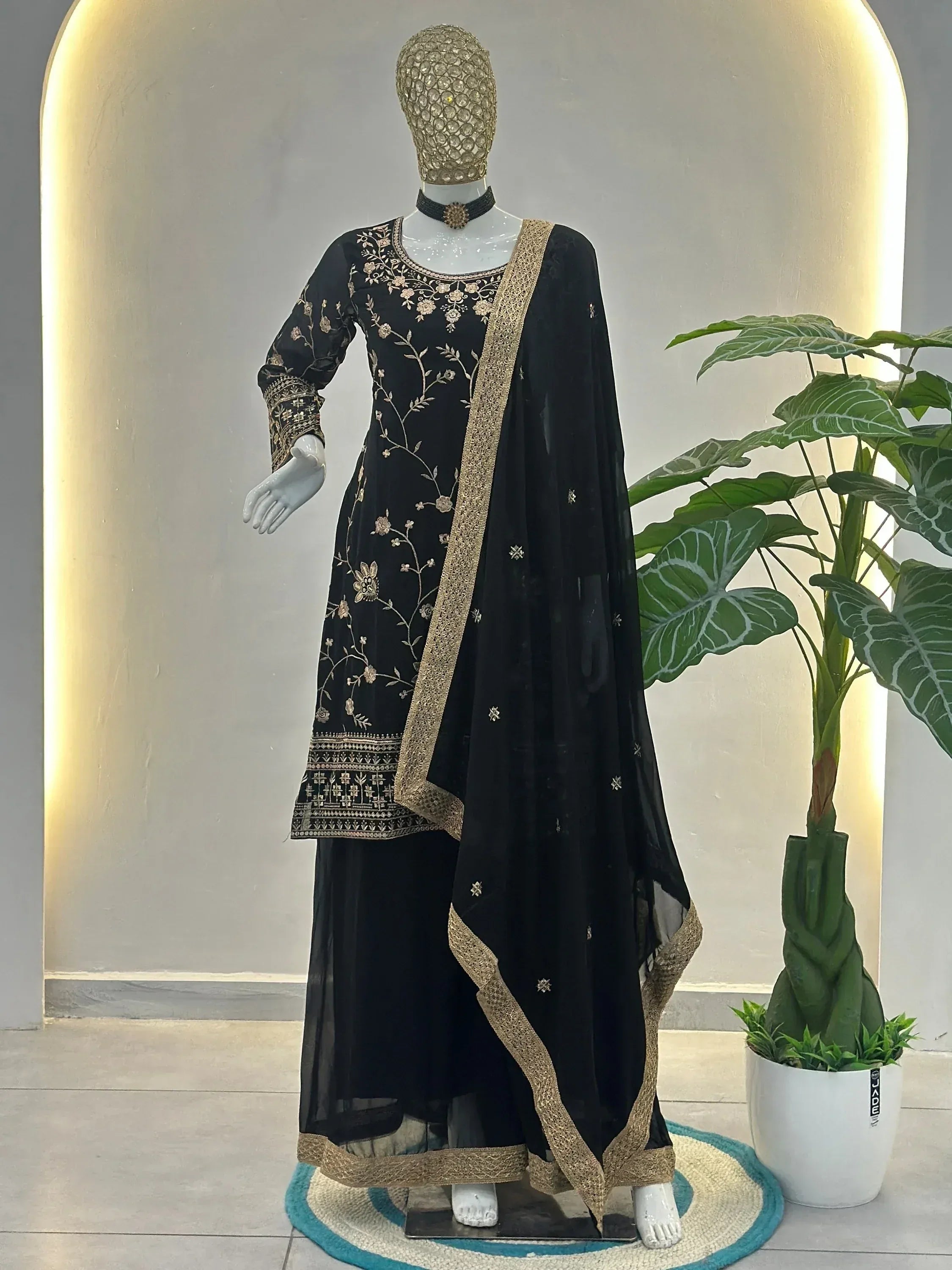 Black embroidered salwar kameez with gold detailing, perfect for ethnic occasions and festive wear.